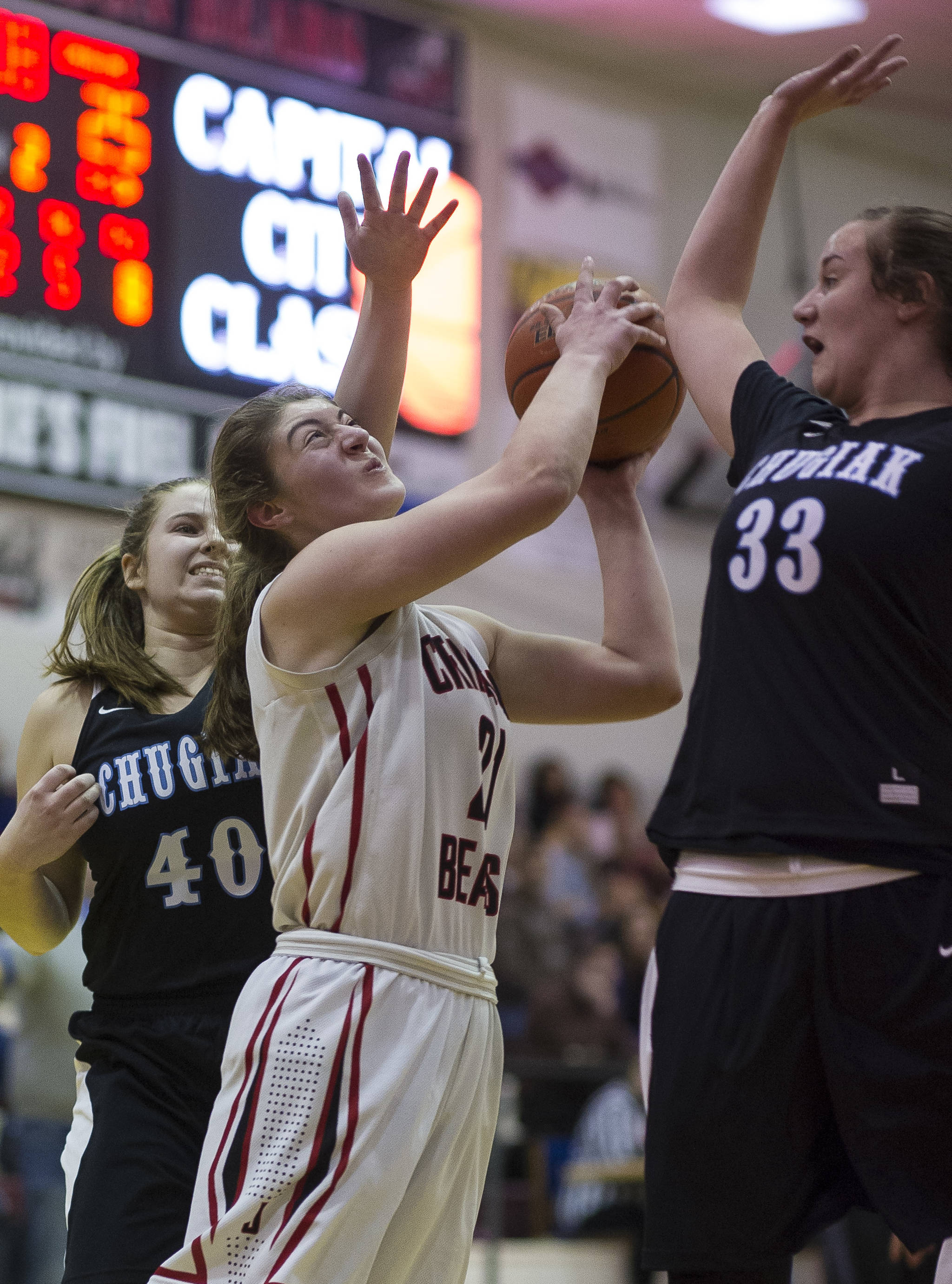 Juneau-Douglas’ Cassie Dzinich, center, goes for a basket against Chugiak’s Patricia Houser, right, and Layla Beam, left, during their Capital City Classic Basketball Tournament game at JDHS on Saturday, Dec. 30, 2017. (Michael Penn | Juneau Empire)
