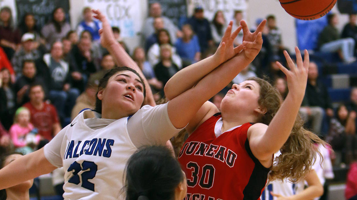 Thunder Mountain’s Nina Fenumiai, left, battles with Juneau-Douglas’ Skylar Hickok for a rebound Saturday night at TMHS. JDHS defeated TMHS in overtime, 46-44. (Don Adams Jr. | For the Juneau Empire)