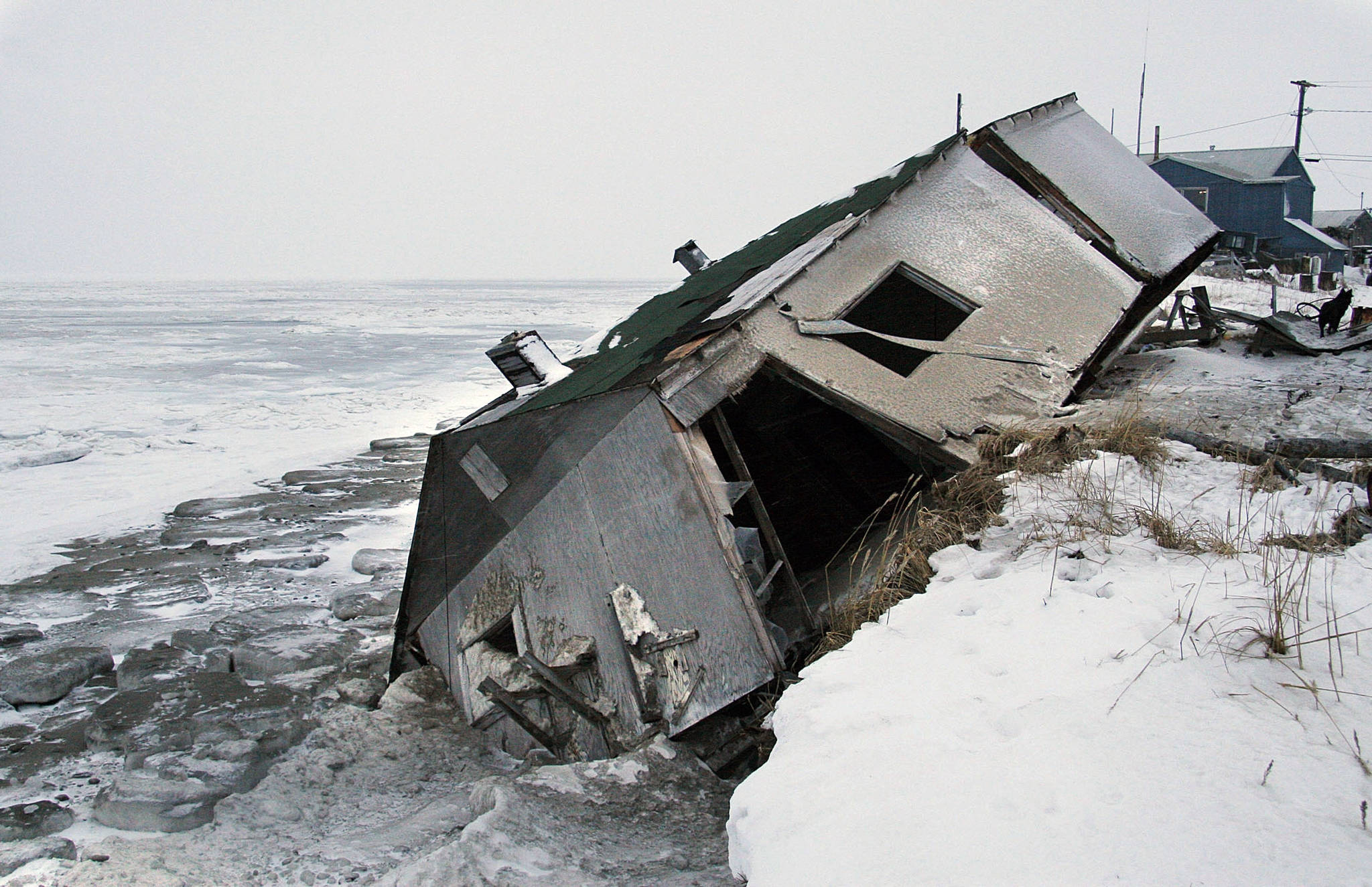 In this Dec. 8, 2006 photo, Nathan Weyiouanna’s abandoned house at the west end of Shishmaref, Alaska, sits on the beach after sliding off during a fall storm in 2005. Alaska health officials are warning that serious health issues could crop up as the state warms. A report by the Alaska Division of Public Health released this week says longer growing seasons and fewer deaths from exposure are likely positive outcomes from climate change. But the 77-page report says additional diseases, lower air quality from more wildfires, melting permafrost and disturbances to local food sources also are potential outcomes. Warming already has thawed soil and eroded coastlines, leading at least three villages, Shishmaref, Kivalina and Newtok to consider relocating. (Diana Haecker | The Associated Press File)
