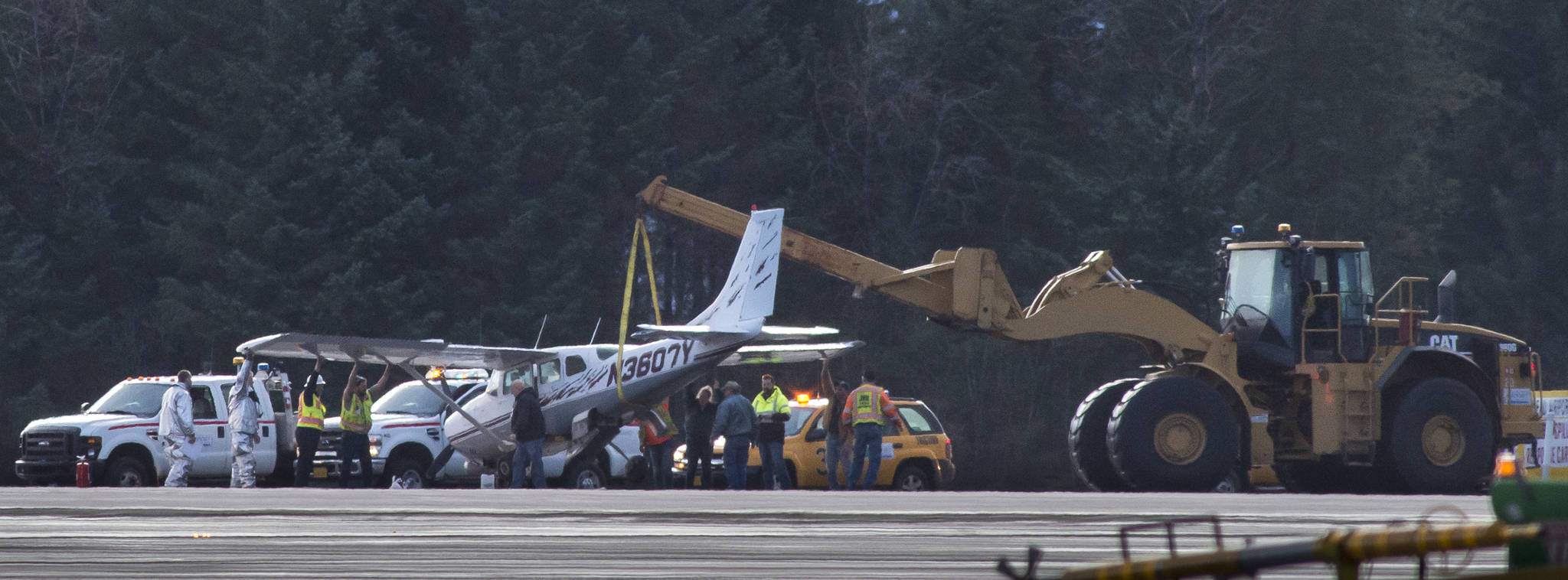 Juneau International Airport firefighters and personnel lift a private aircraft that had landing gear failure while landing at the airport on Sunday, Jan. 14, 2018. (Michael Penn | Juneau Empire)