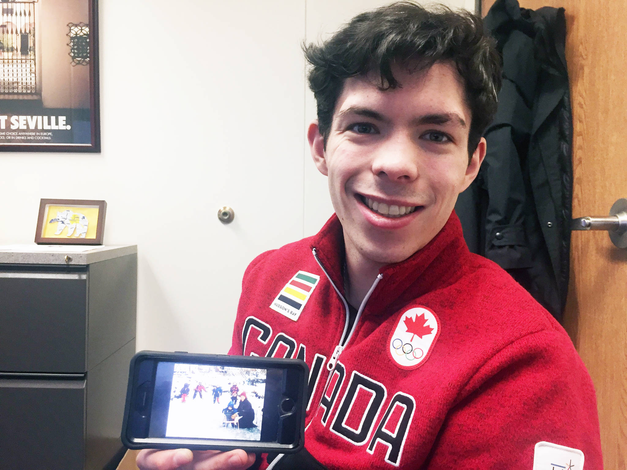 Keegan Messing shows off a childhood photo of his family on ice skates during his trip to Juneau Friday. (Nolin Ainsworth | Juneau Empire)
