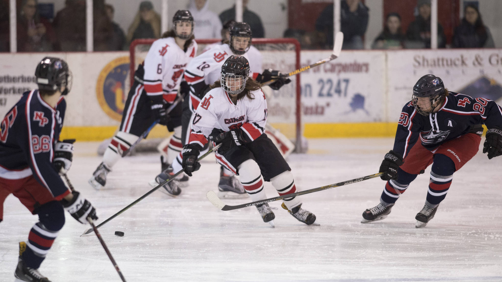 Juneau-Douglas&rsquo; Billy Bosse, moves the puck up against North Pole&rsquo;s Jesse Keith, right, at Treadwell Arena on Friday, Jan. 19, 2018. (Michael Penn | Juneau Empire)