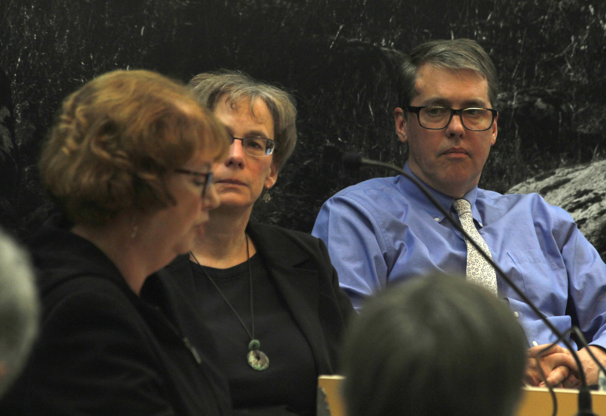 Deputy City Manager Mila Cosgrove, center, and City Manager Rorie Watt, right, listen to the testimony of Janet Clarke-Kennedy at Monday’s City and Borough of Juneau Assembly meeting. Despite arguments from Clarke-Kennedy and 16 other members of the public asking them not to go forward with expanding the city’s borders farther on Admiralty Island, the Assembly members voted by a 5-4 count to go ahead with it. (Alex McCarthy | Juneau Empire)