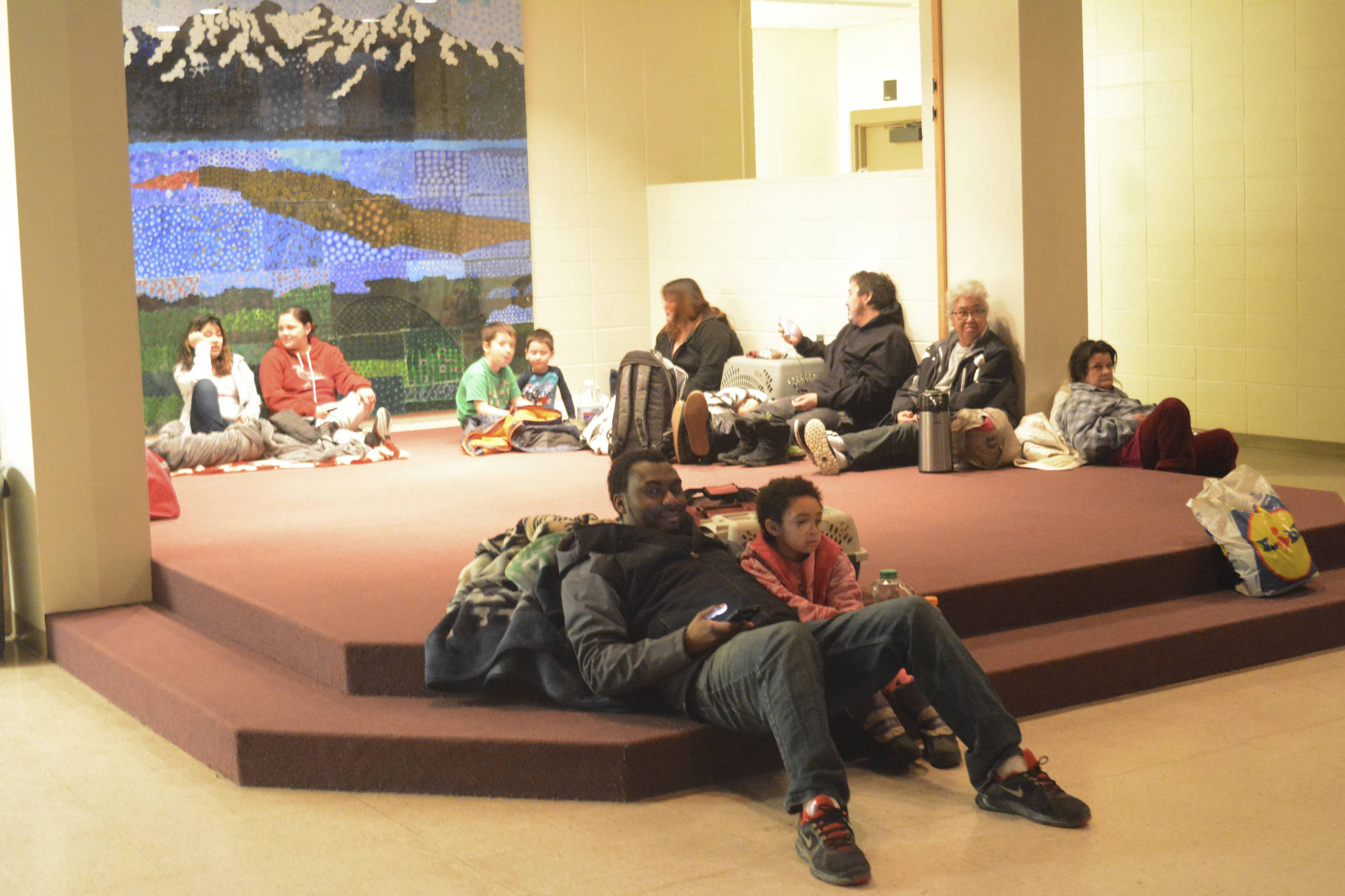 Abdulai Salam and his daughter Mina at about 2:30 a.m. Tuesday, Jan. 23, 2018, wait for the all-clear at Homer High School during a tsunami alert for Homer. The city of Homer issued an evacuation order for low-lying areas shortly after an earthquake hit. (Michael Armstrong | Homer News)