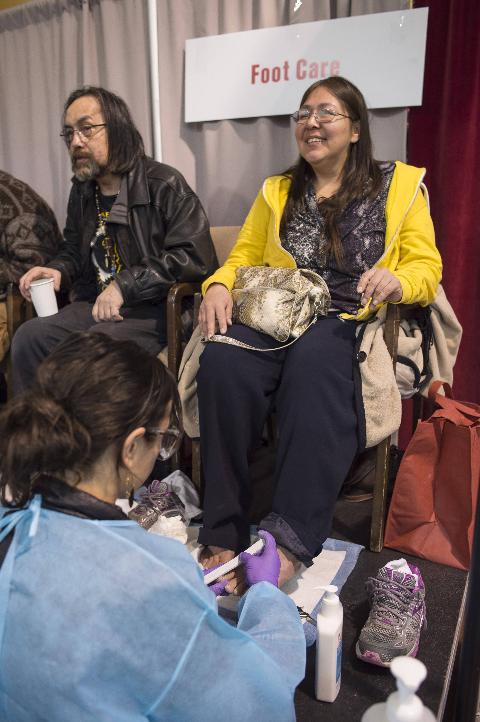Heather Lee, right, and Michael George Patterson receive foot care during the Juneau Coalition on Housing & Homelessness’ 7th annual Project Homeless Connect in the Juneau Arts & Culture Center on Wednesday, Jan. 24, 2018. (Michael Penn | Juneau Empire)