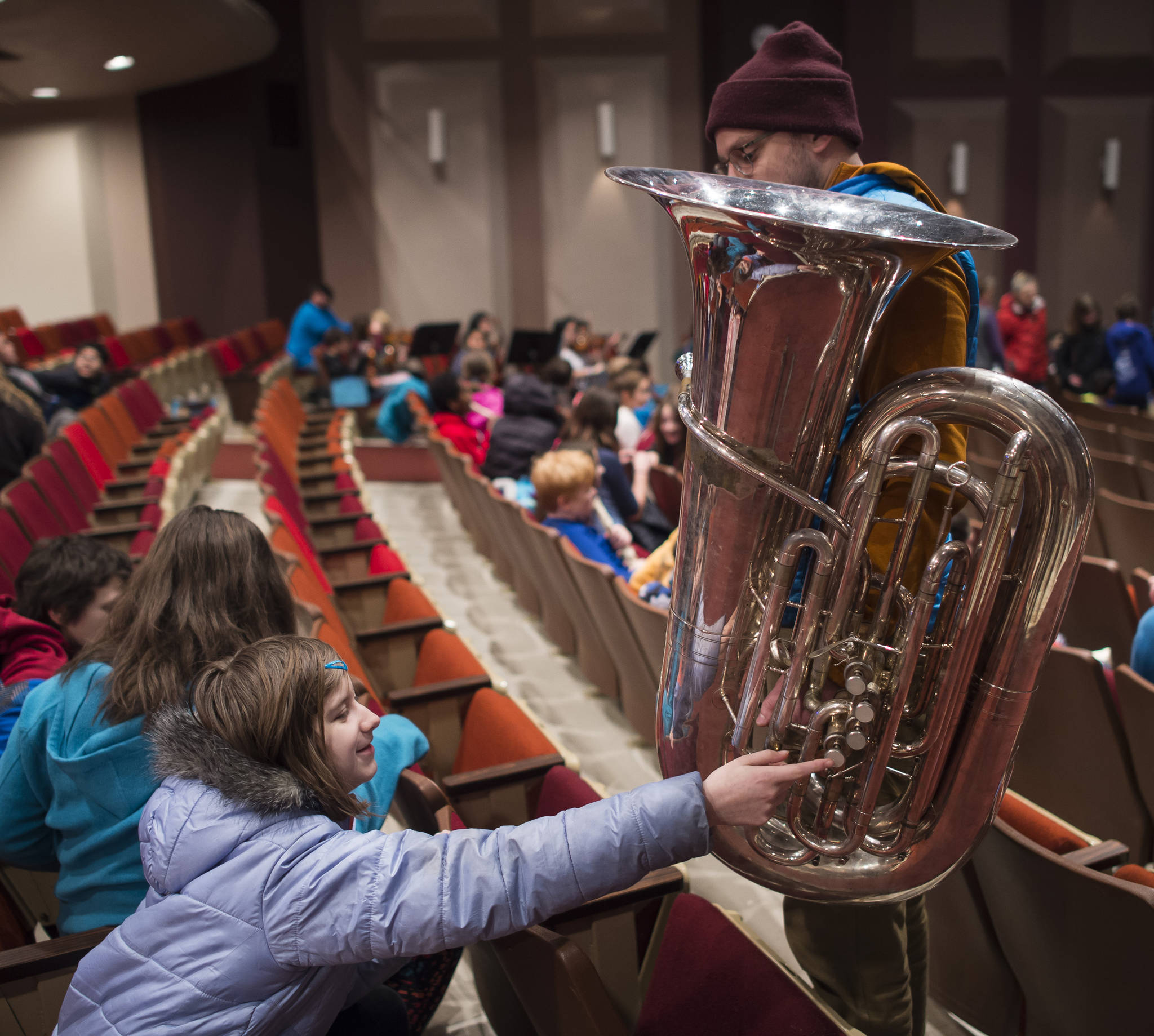 Riverbend Elementary School fifth-grader Sofia Lindoff gets a closeup view of Stephen Young’s tuba as Juneau School District fifth-graders attend a program by the Juneau Symphony Orchestra and Conductor Troy Quinn titled “The Orchestra Sings!” in the Juneau-Douglas High School Auditorium on Friday, Jan. 26, 2018. The Symphony Excursion for 5th Grade is part of Juneau’s ANY GIVEN CHILD programming. (Michael Penn | Juneau Empire)
