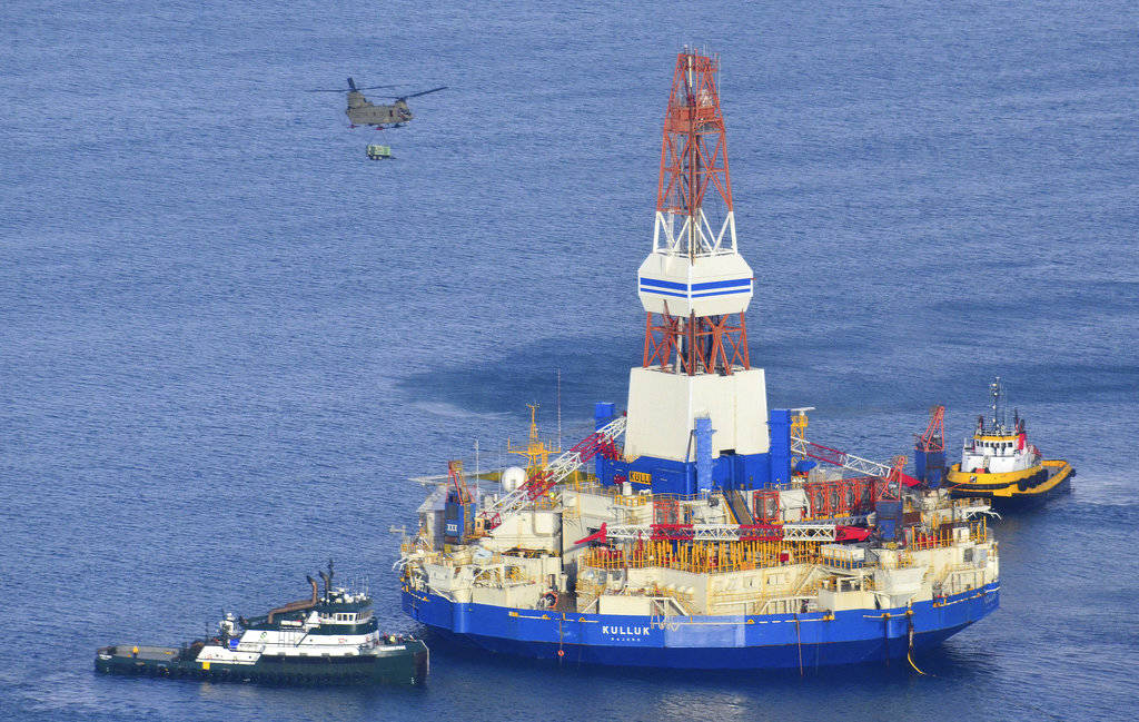 In this Jan. 7, 2013 photo, a U.S. Army CH-47 Chinook helicopter flies over the Kulluk, the Shell floating drilling barge off Kodiak Island in Alaska’s Kiliuda Bay, as salvage teams conduct an in-depth assessment of its seaworthiness. Citing the disappointing results from an exploratory well in 2015, and challenging and unpredictable federal regulatory environment, Shell abandoned drilling in U.S. Arctic waters. The Trump administration is pursuing petroleum lease sales in Arctic waters but an analyst says potential bidders may find other areas more attractive. (James Brooks | Kodiak Daily Mirror File)