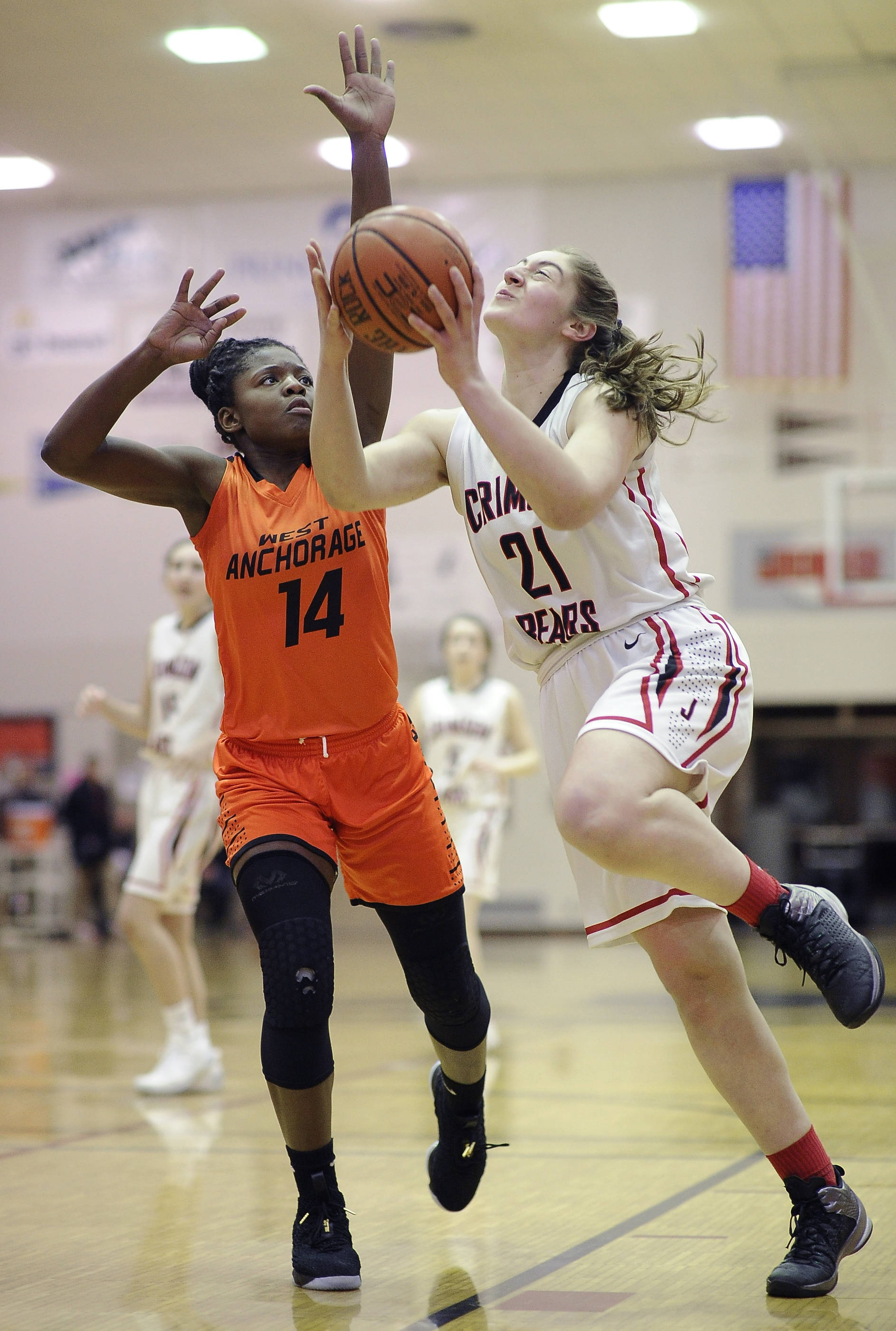 Juneau-Douglas&rsquo; Cassie Dzinich, right, drives to the basket against West&rsquo;s Nyeniea John during their game on Friday, Feb. 2, 2018. (Michael Penn | Juneau Empire)