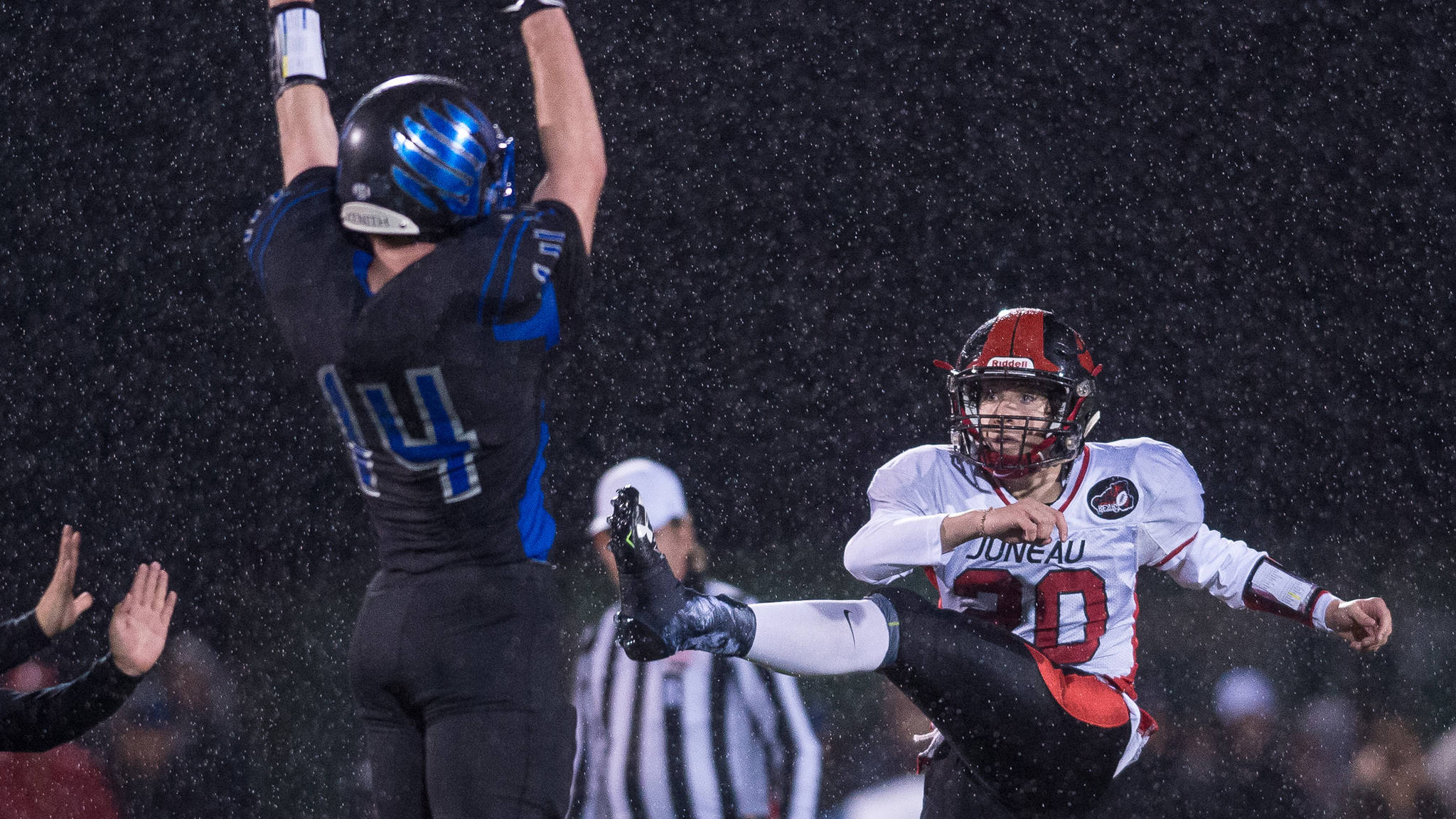 Thunder Mountain’s Caleb Traxler, left, attempts to block Juneau-Douglas’ Cooper Kriegmont’s punt at TMHS in September. The two Juneau football programs are now officially known as the “Juneau Thunder Bears.” (Michael Penn | Juneau Empire File)
