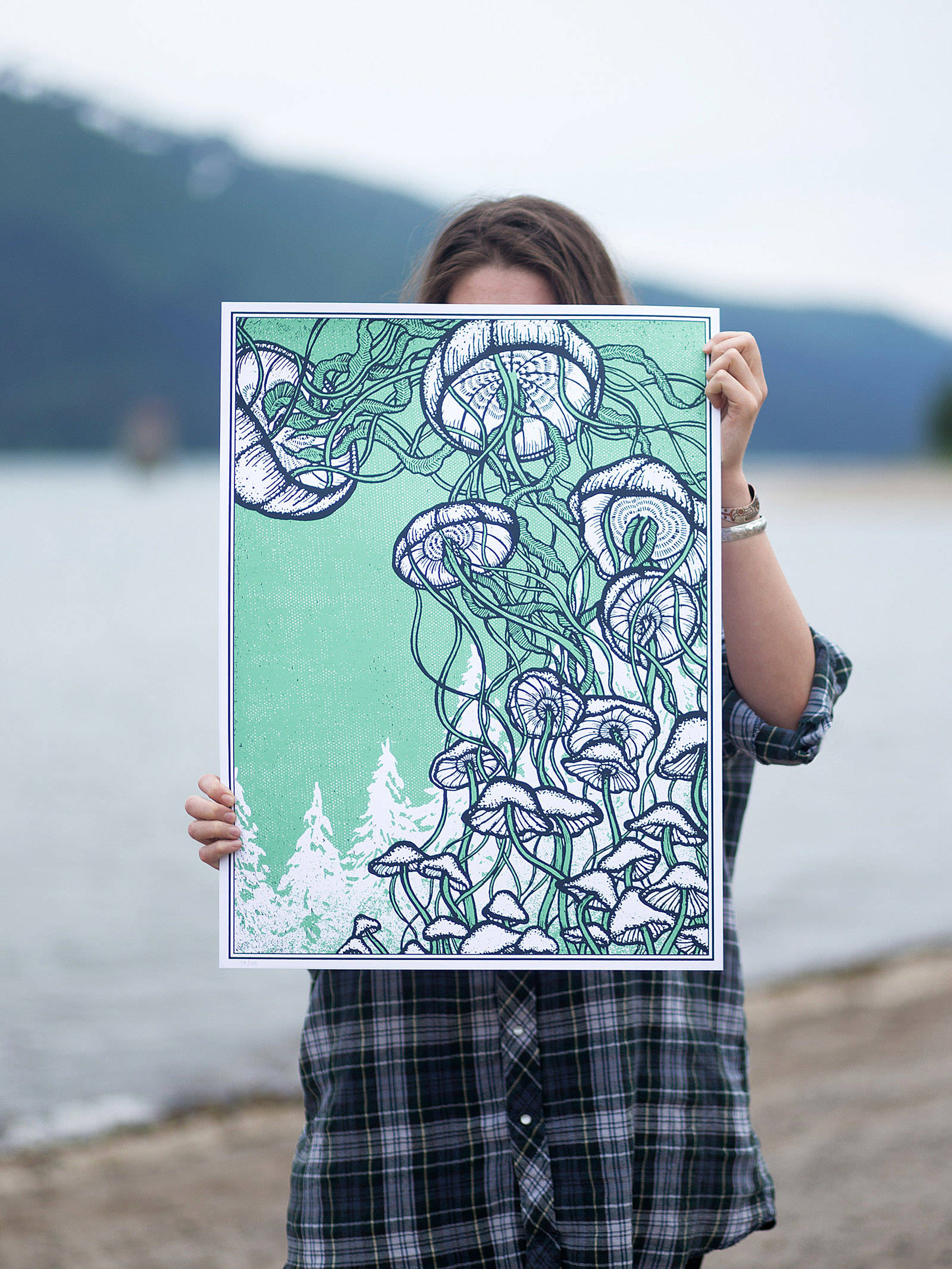 Michaela Goade holds up one of her art pieces at Sandy Beach. Courtesy image.