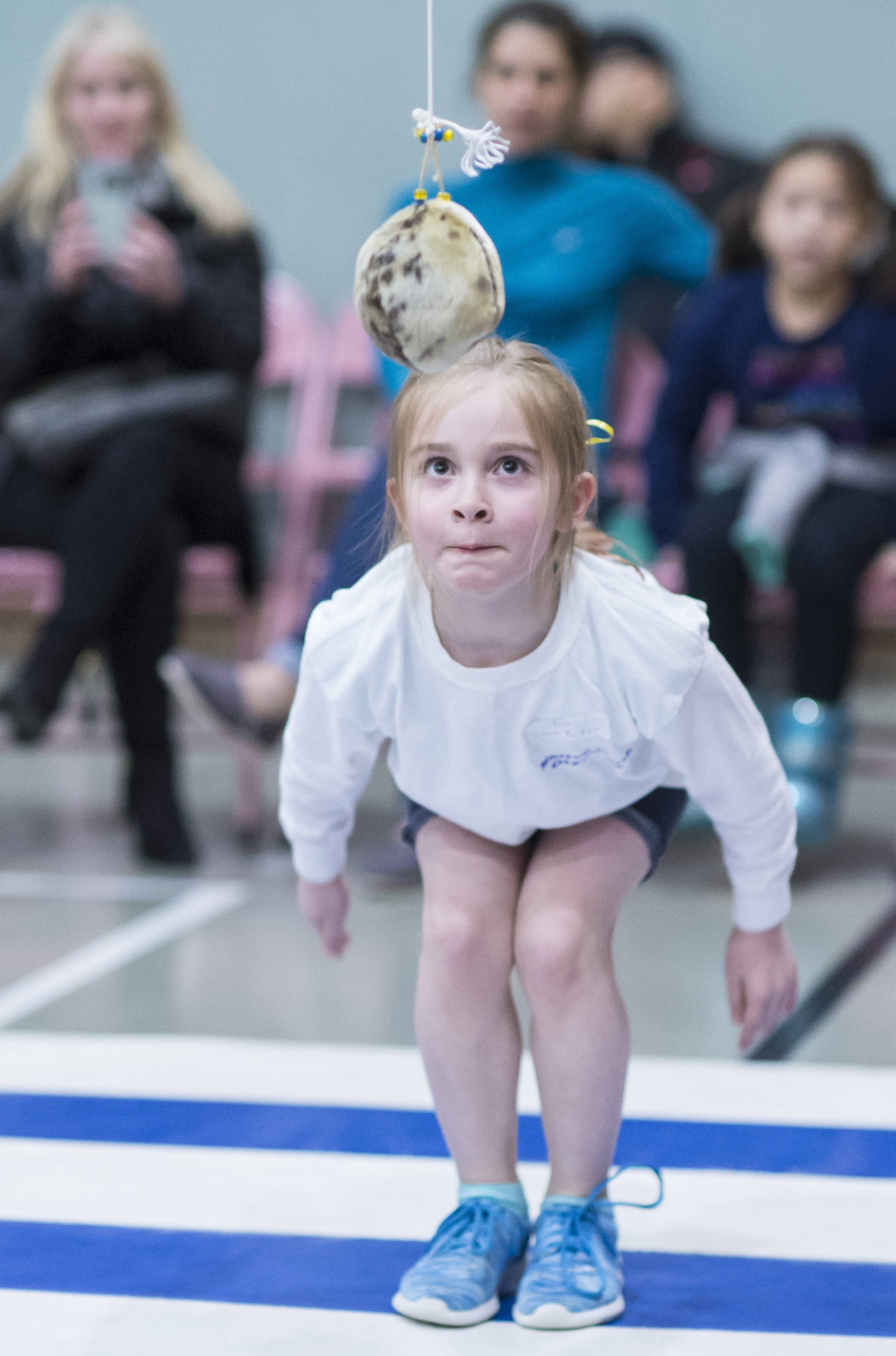 Second-grader Laura Parker, of Riverbend Elementary School, concentrates on her Alaska high kick during the Native Youth Olympics at Riverbend Elementary School on Friday, Feb. 9, 2018. (Michael Penn | Juneau Empire)