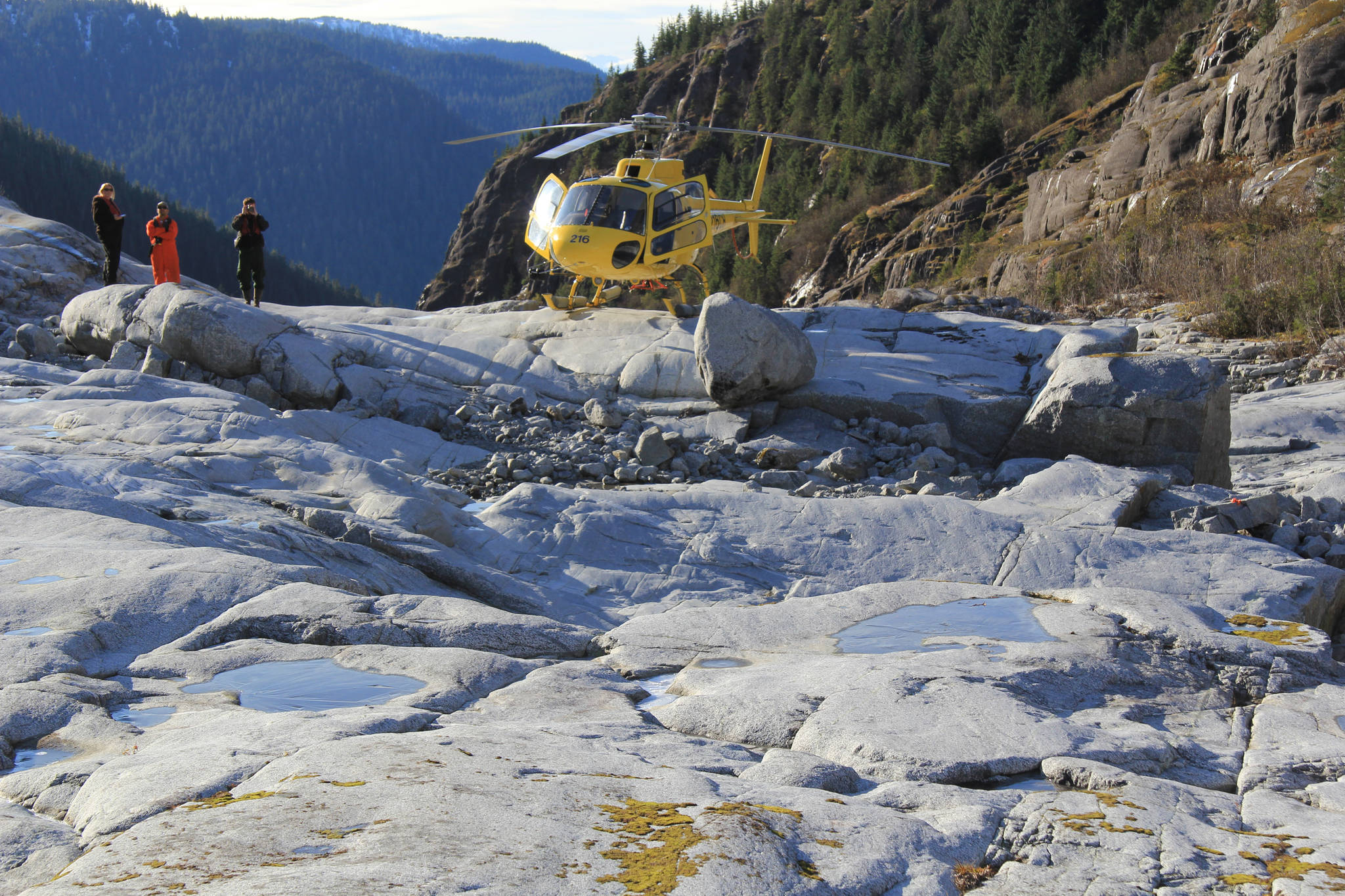 Forest Service Employees inspect the sight of an alpine tsunami on the Cowee Creek Channel. On Dec. 30, 2016, a 30-foot tall tsunami scoured the creek&rsquo;s shoreline, exposing the grey rock in the foreground. (Photo courtesy the U.S. Forest Service and Rick Edwards)
