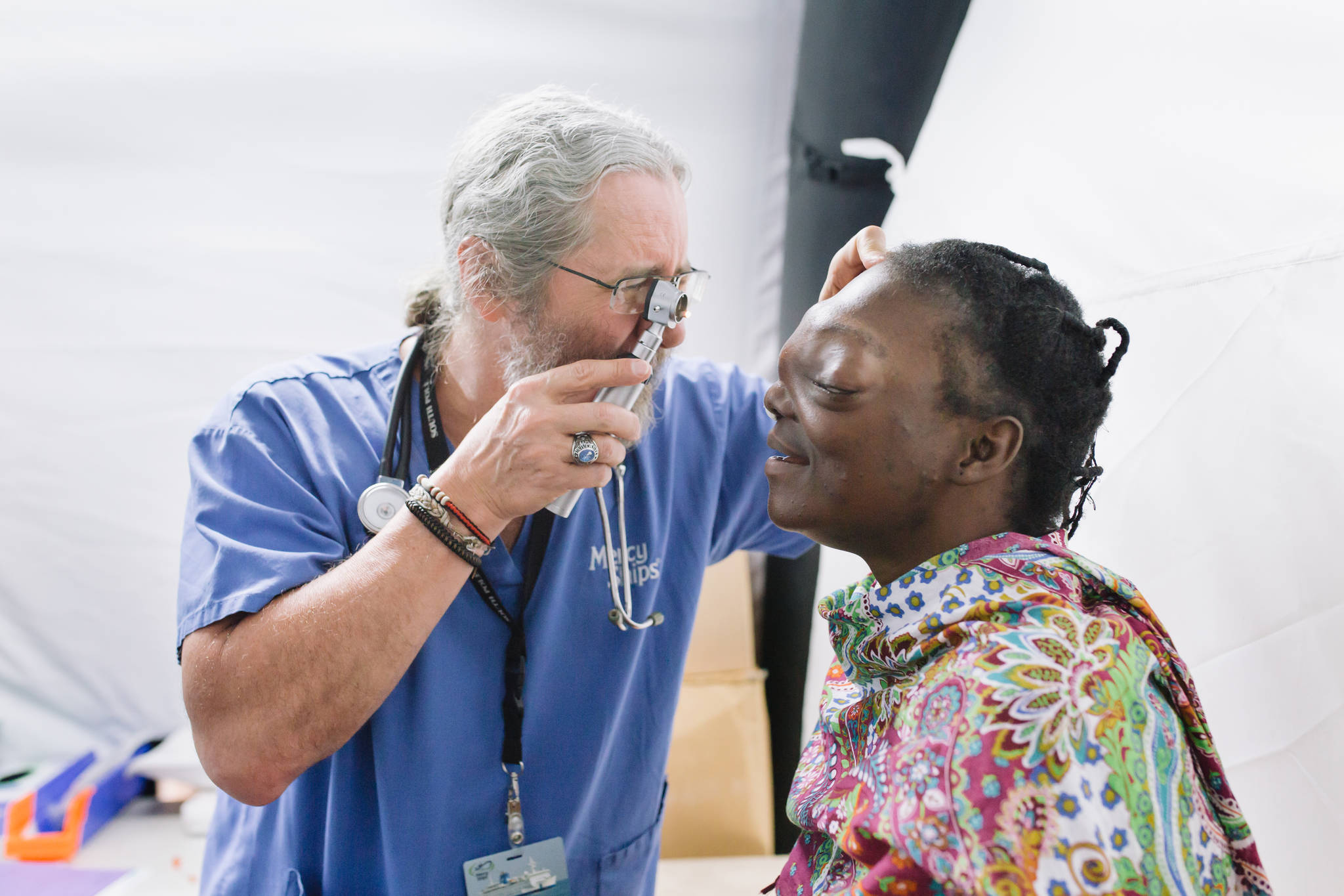 Mercy Ships volunteer Hospital Physician, Dr. Mark Peterson, examines a patient before their admission to the Africa Mercy for surgery. (Shawn Thompson | Mercy Ships)