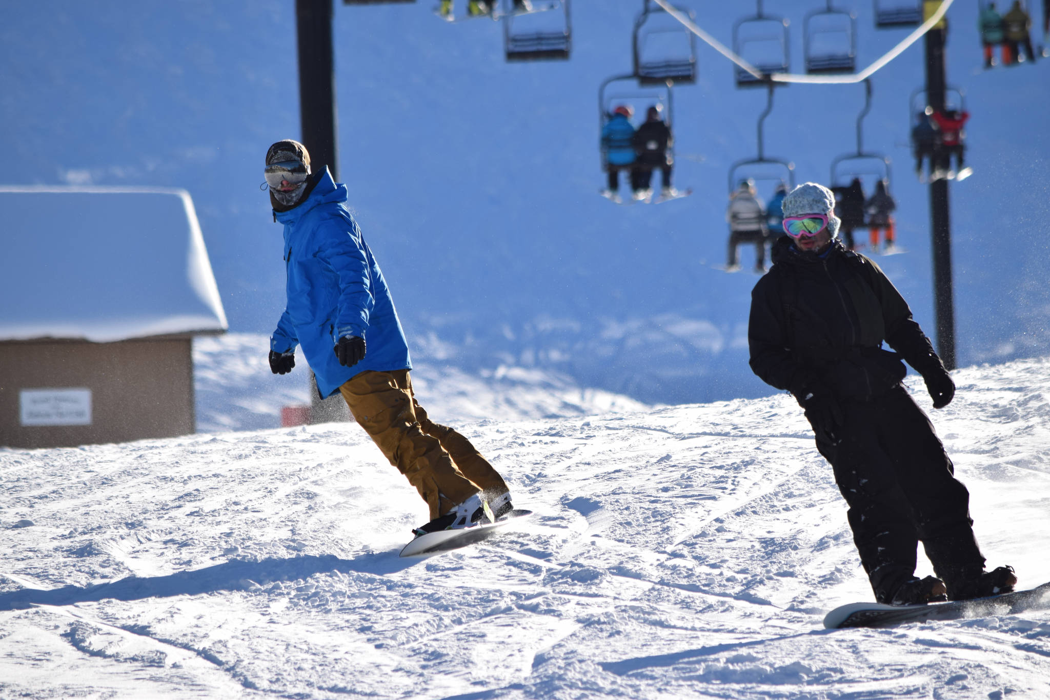 Two snowboarders finish a run at the bottom of the Ptarmigan chairlift at Eaglecrest Ski Area on Saturday. (Kevin Gullufsen | Juneau Empire)