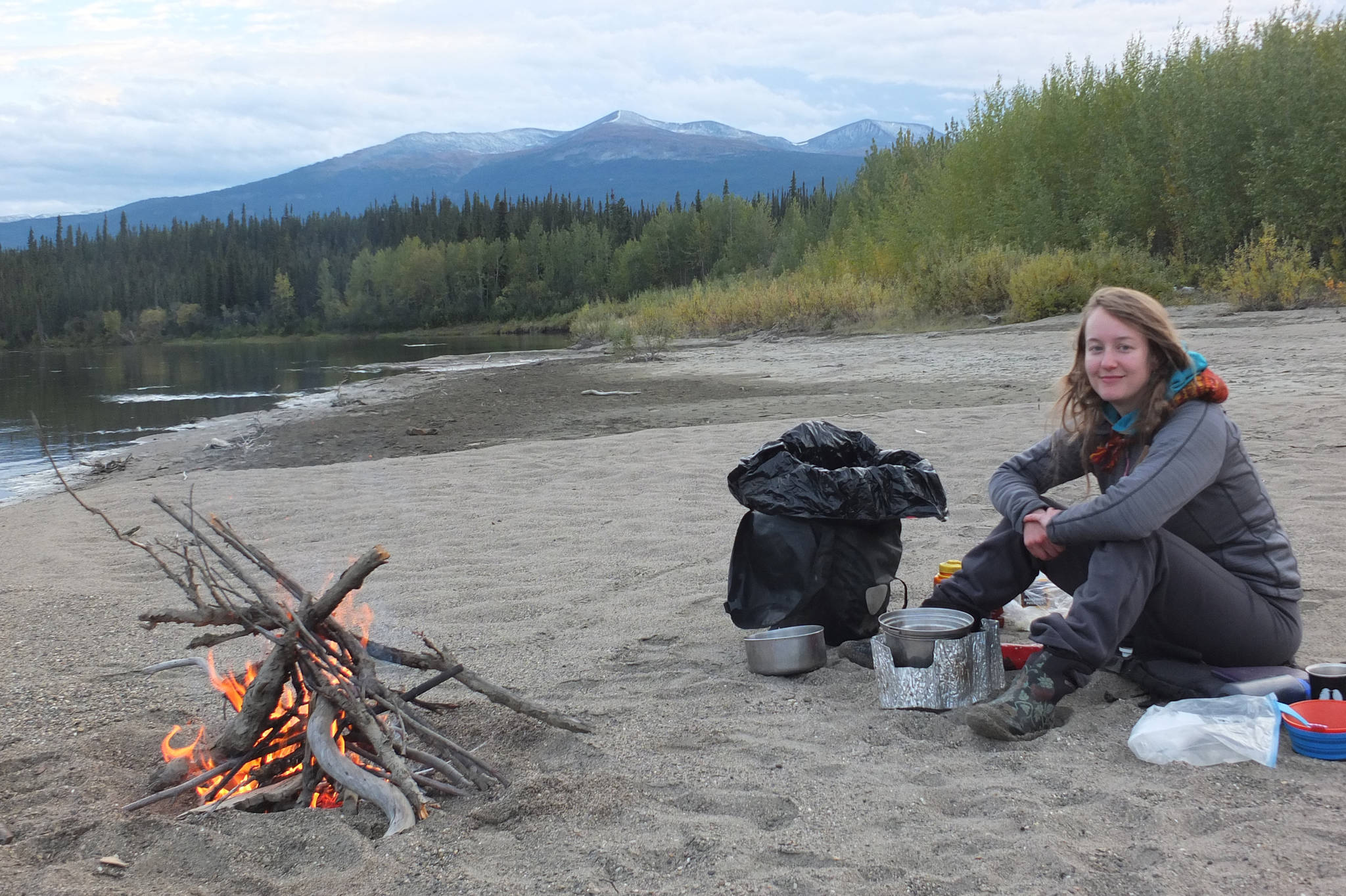 Mary Catharine Martin cooks dinner along the Nisutlin River in the Yukon in September 2014. Photo by Bjorn Dihle