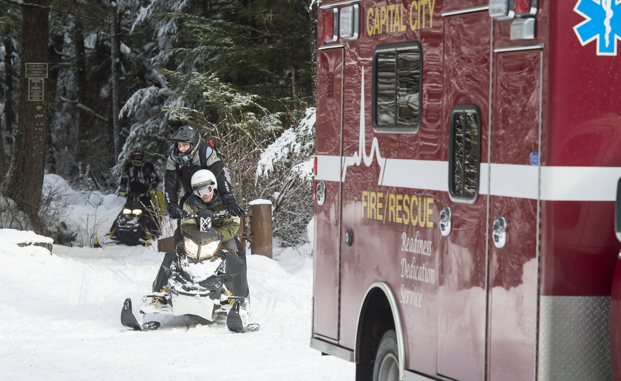 Capital City Fire/Rescue firefighter Blake Fleming and other members of CCFR’s rescue team arrive at the Spaulding Meadows snowmachine trail with a man rescued from the John Muir Cabin on Wednesday, Feb. 28, 2018. The man was said to have had a medical issue. Juneau Snowmobile Club members helped in the rescue. (Michael Penn | Juneau Empire)