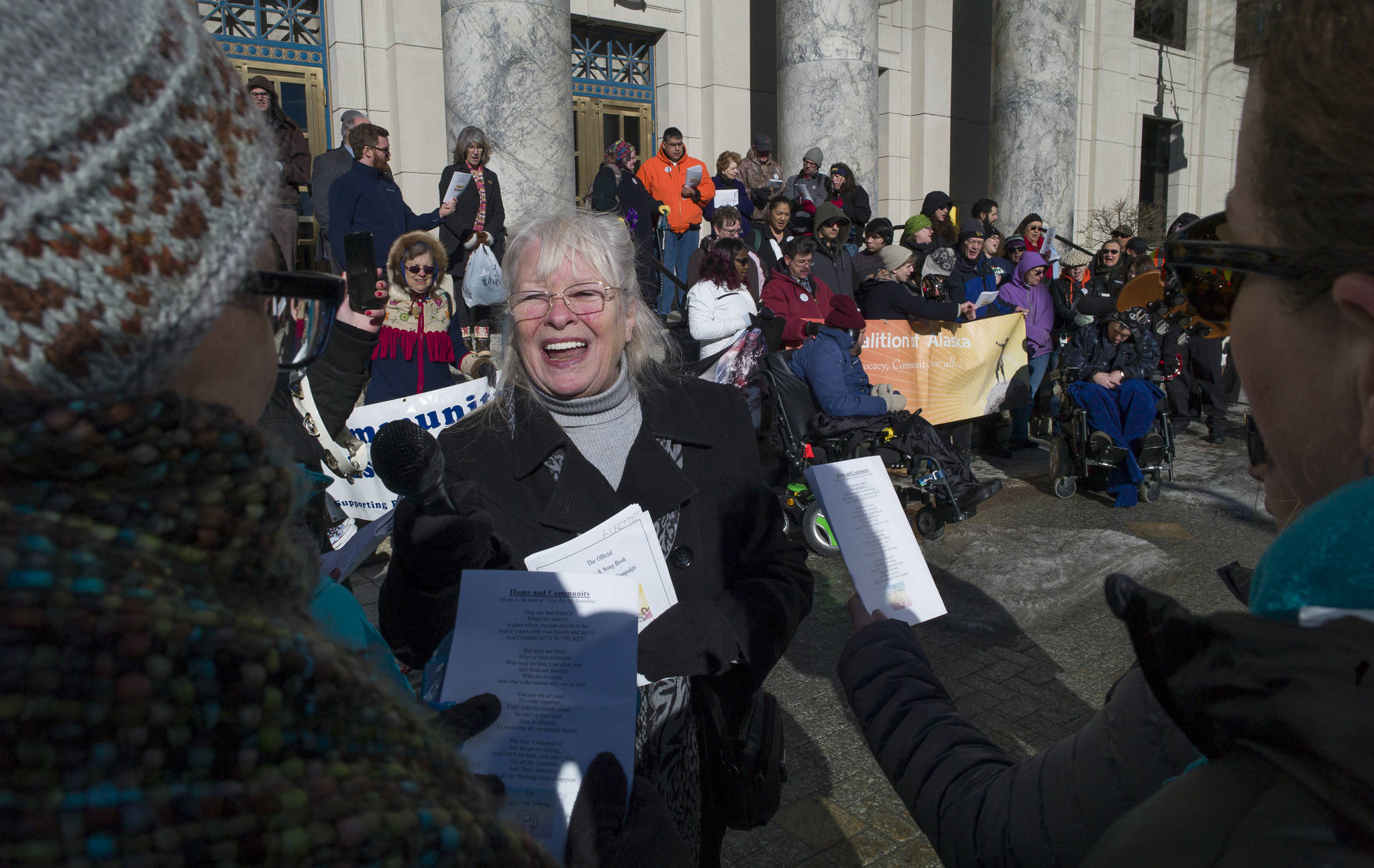 Lizette Stiehr, executive director for the Alaska Association on Developmental Disabilities, holds up a loud speaker microphone during singing at Key Coalition Rally at the Capitol on Friday, March 2, 2018. The Key Coalition of Alaska educates legislators about the importance of sustaining community-based services for people with disabilities and Intellectual and Developmental Disabilities. (Michael Penn | Juneau Empire)
