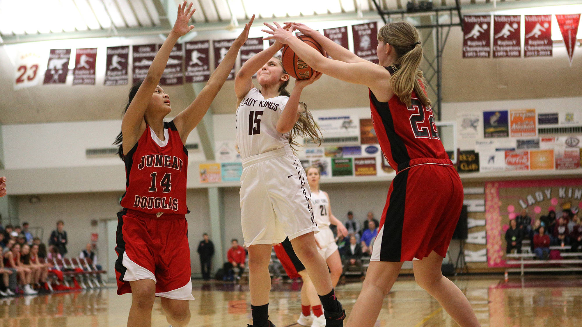 Juneau-Douglas’ Alyxn Bohulano, left, and Caitlin Pusich reach out to block Ketchikan’s Madison Rose Wednesday night at Ketchikan High School. The Lady Kings defeated the Crimson Bears 59-50 and can win the Region V 4A championship with a win on Friday. (Dustin Safranek | Ketchikan Daily News)