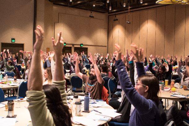 Participants at the 2017 AEYC conference raise their hands. (Courtesy photo | Dave Newton)