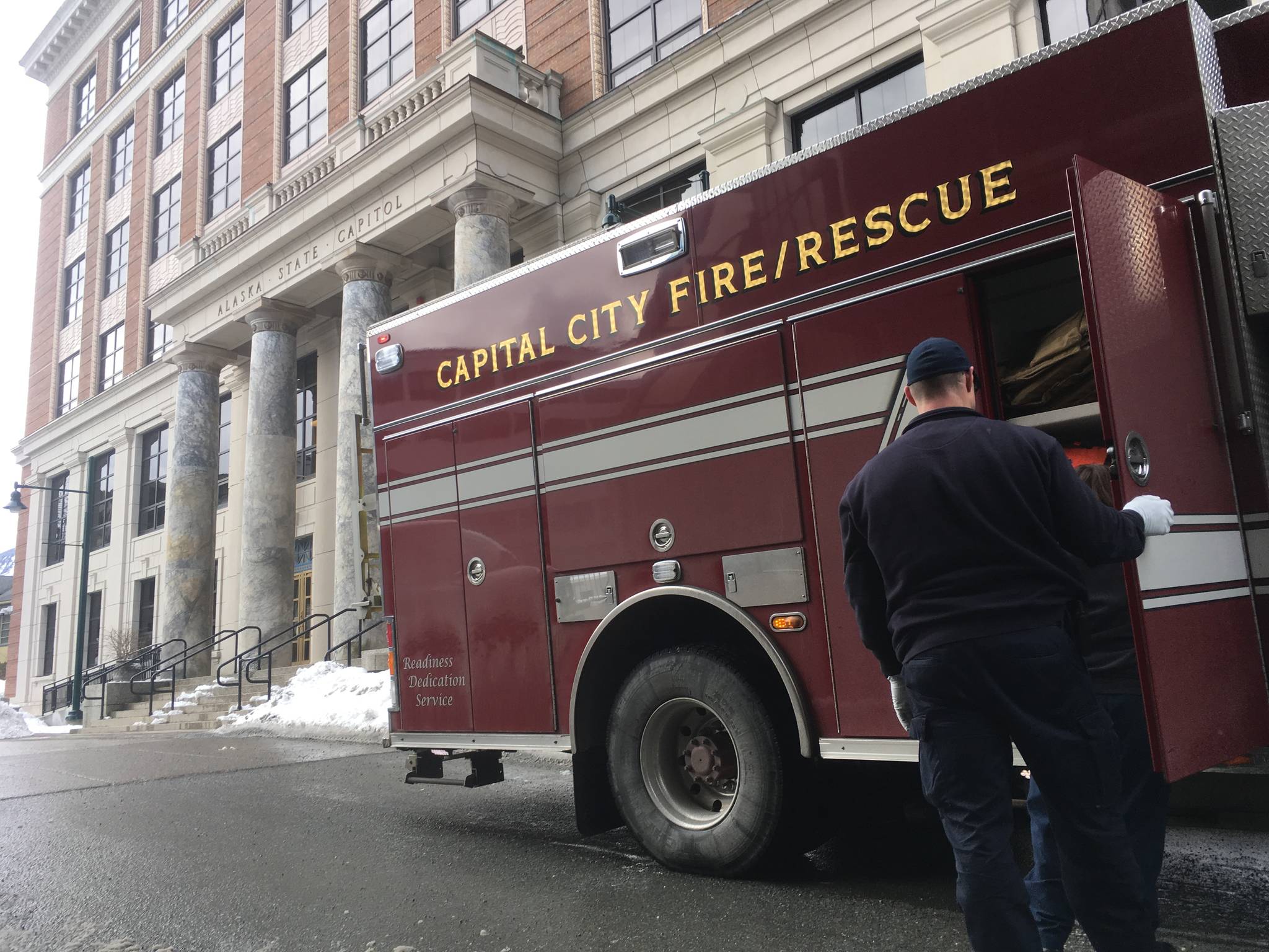 Capital City Fire/Rescue workers return gear to an emergency vehicle in front of the Alaska State Capitol on Thursday afternoon, March 8, 2018. (James Brooks | Juneau Empire)