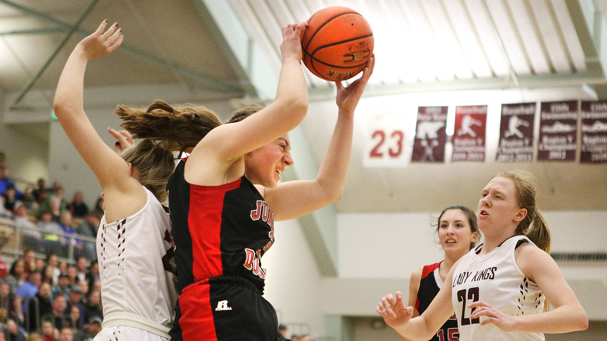Juneau-Douglas’ Cassie Dzinich runs back-to-back with Ketchikan’s Emmie Smith as Ketchikan’s Hannah Maxwell, right, looks on Friday during the Region V 4A championship game. Ketchikan won 52-44. (Dustin Safranek | Ketchikan Daily News)