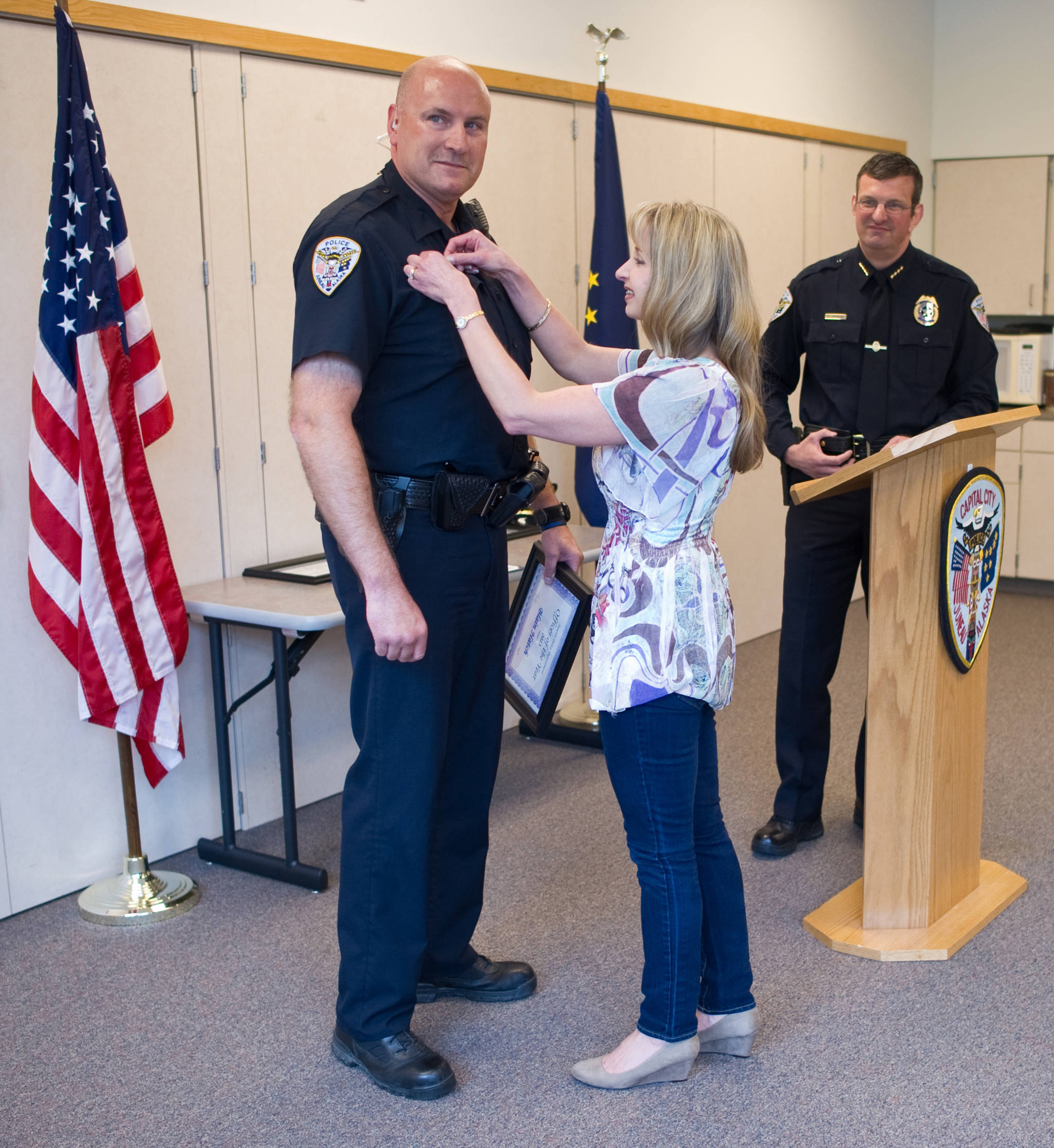 Juneau Police Department Sgt. Blain Hatch is pinned by his wife, Tiffany, after being named Officer of the Year for 2013 by the police chief, Bryce Johnson, during the Quarterly Award Ceremony in May 2014. (Michael Penn | Juneau Empire)