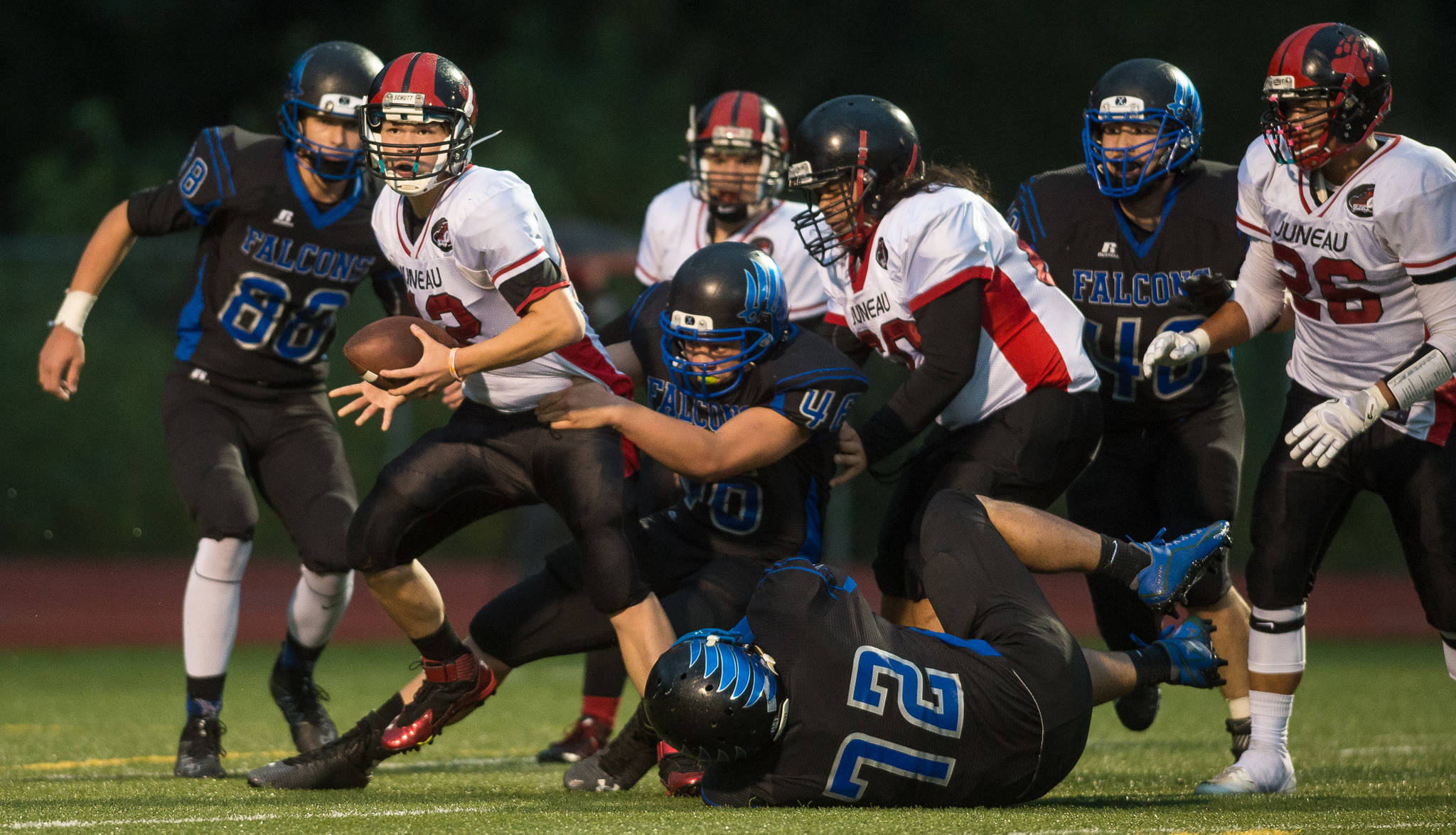 In this Sept. 1, 2017 photo, Juneau-Douglas&rsquo; quarterback Max Wheat is sacked by Thunder Mountain&rsquo;s Puna Touteiolepo at TMHS. TMHS won 10-7 in overtime. (Michael Penn | Juneau Empire File)