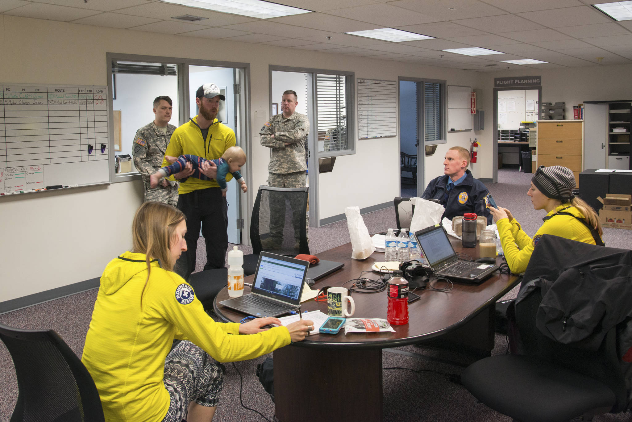 Juneau Mountain Rescue personnel discuss search priorities at the Army National Guard hangar in Juneau while waiting for a weather window to fly. (Courtesy photo | Ben Huff)