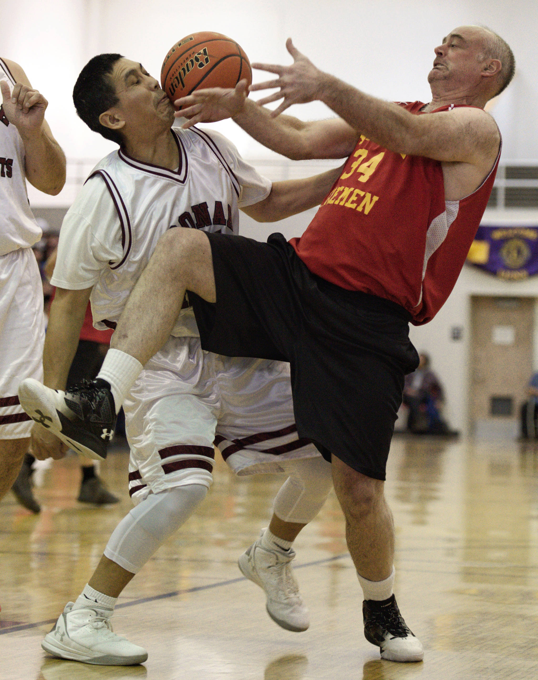 Hoonah’s Kin Willard Jr., left, and Kake’s Jeff Dean fight for a rebound in the Master’s bracket final at the Juneau Lion’s Gold Medal Basketball Tournament at Juneau-Douglas High School on Saturday, March 24, 2018. (Michael Penn | Juneau Empire)