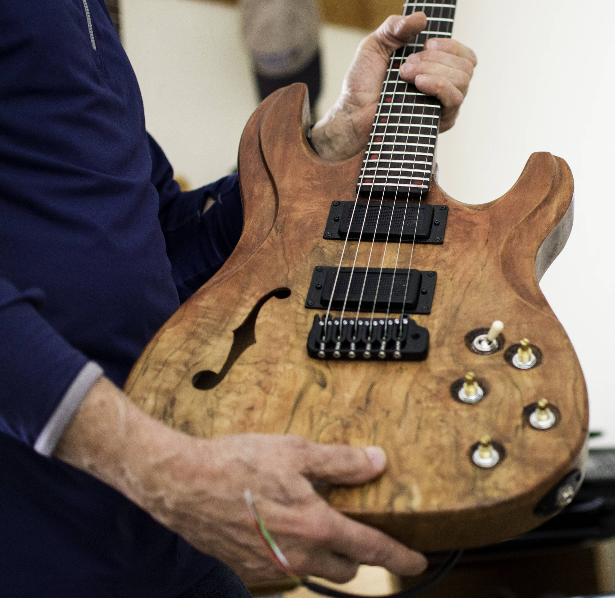 George Gress holds a guitar he made from repurposed wood at his home in Juneau on Tuesday, March 27, 2018. Richard McGrail | For the Capital City Weekly