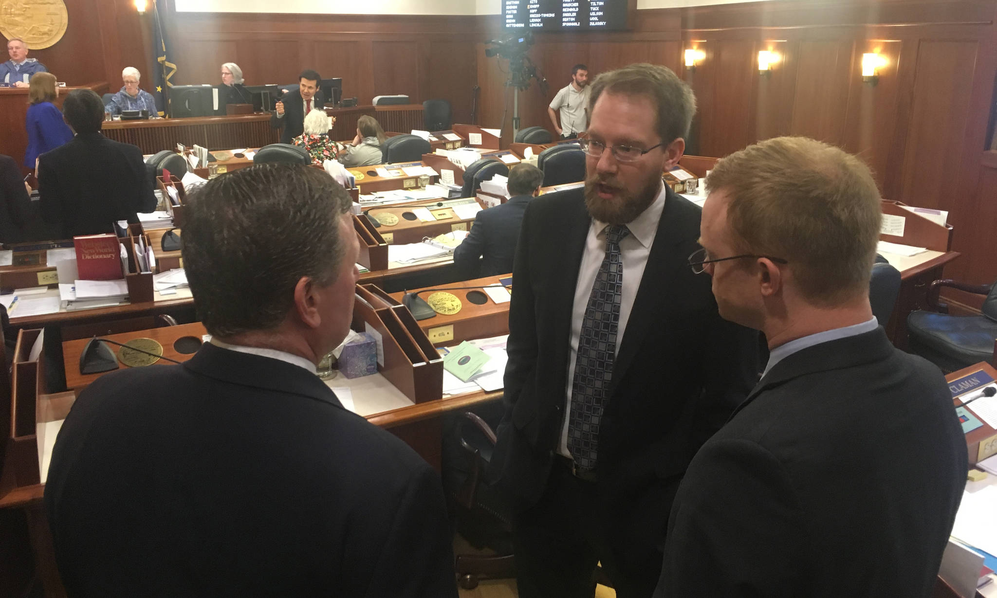 Rep. Lance Pruitt, R-Anchorage, center, talks to Rep. Chuck Kopp, R-Anchorage, left, and Rep. David Eastman, R-Wasilla during a break in the floor session Friday, March 30, 2018. (James Brooks | Juneau Empire)