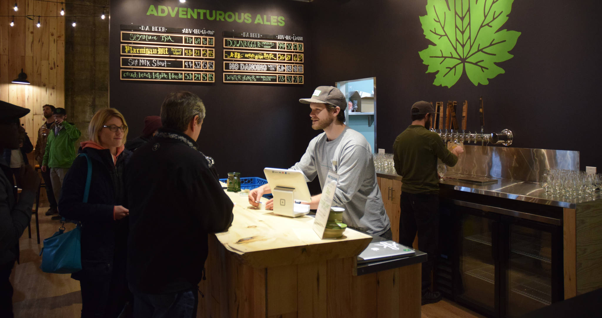 Devil’s Club Brewing Co.’s Evan Wood talks to customers at the microbrewery’s new taproom on Franklin Street on Wednesday. (Kevin Gullufsen | Juneau Empire)