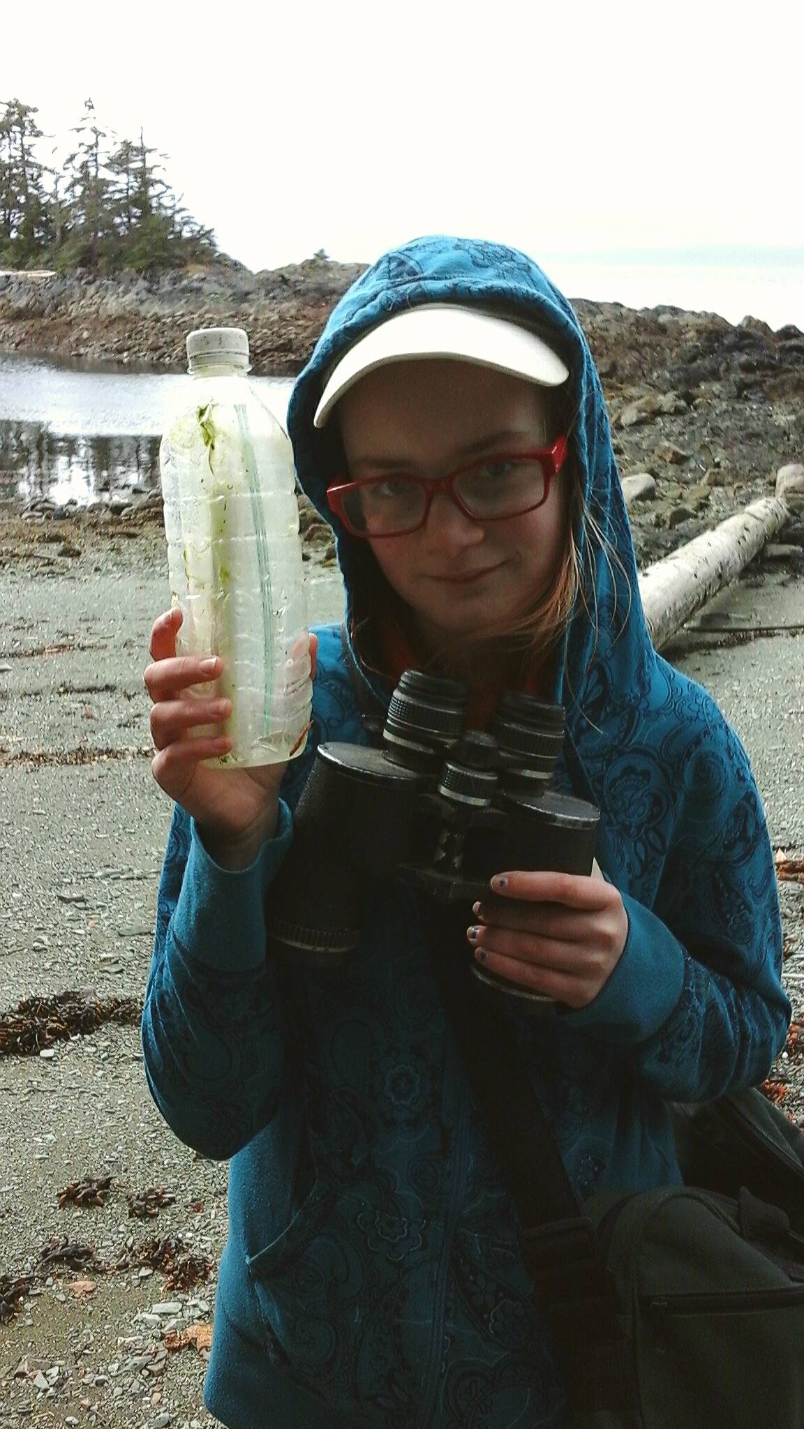 A.C. Dearden holds up the message in a bottle with Clarence Strait behind her. Tara Neilson | For the Capital City Weekly