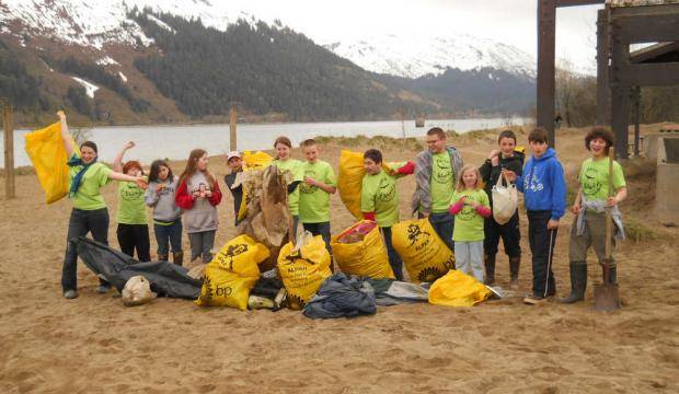 In this 2012 file photo, students from Raven Correspondence School pose at Sandy Beach after a litter cleanup on Earth Day. (Courtesy photo)
