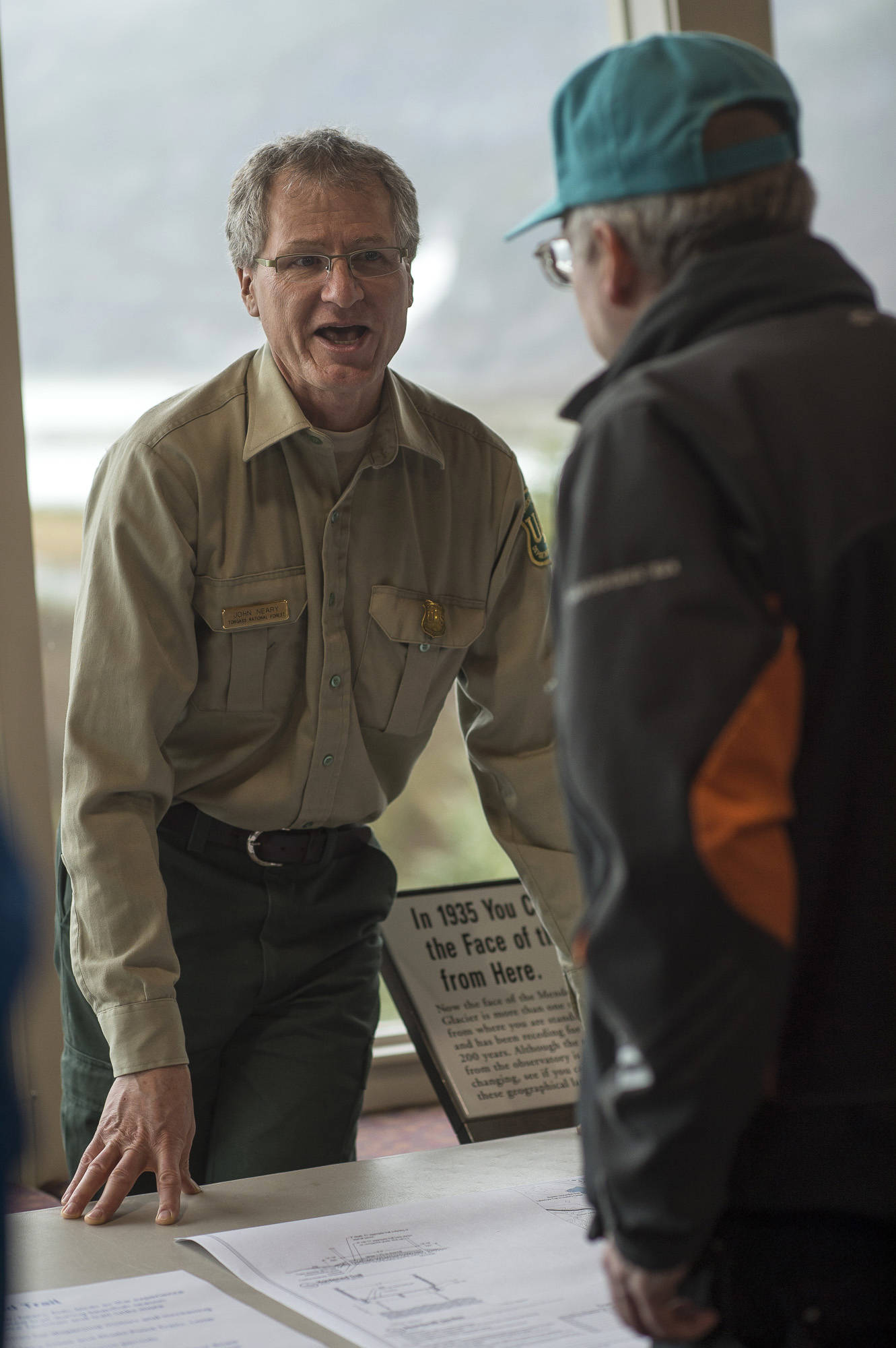 Director John Neary talks to a Juneau resident about plans for possible changes at the Mendenhall Glacier Visitor Center on Thursday, April 26, 2018. (Michael Penn | Juneau Empire)