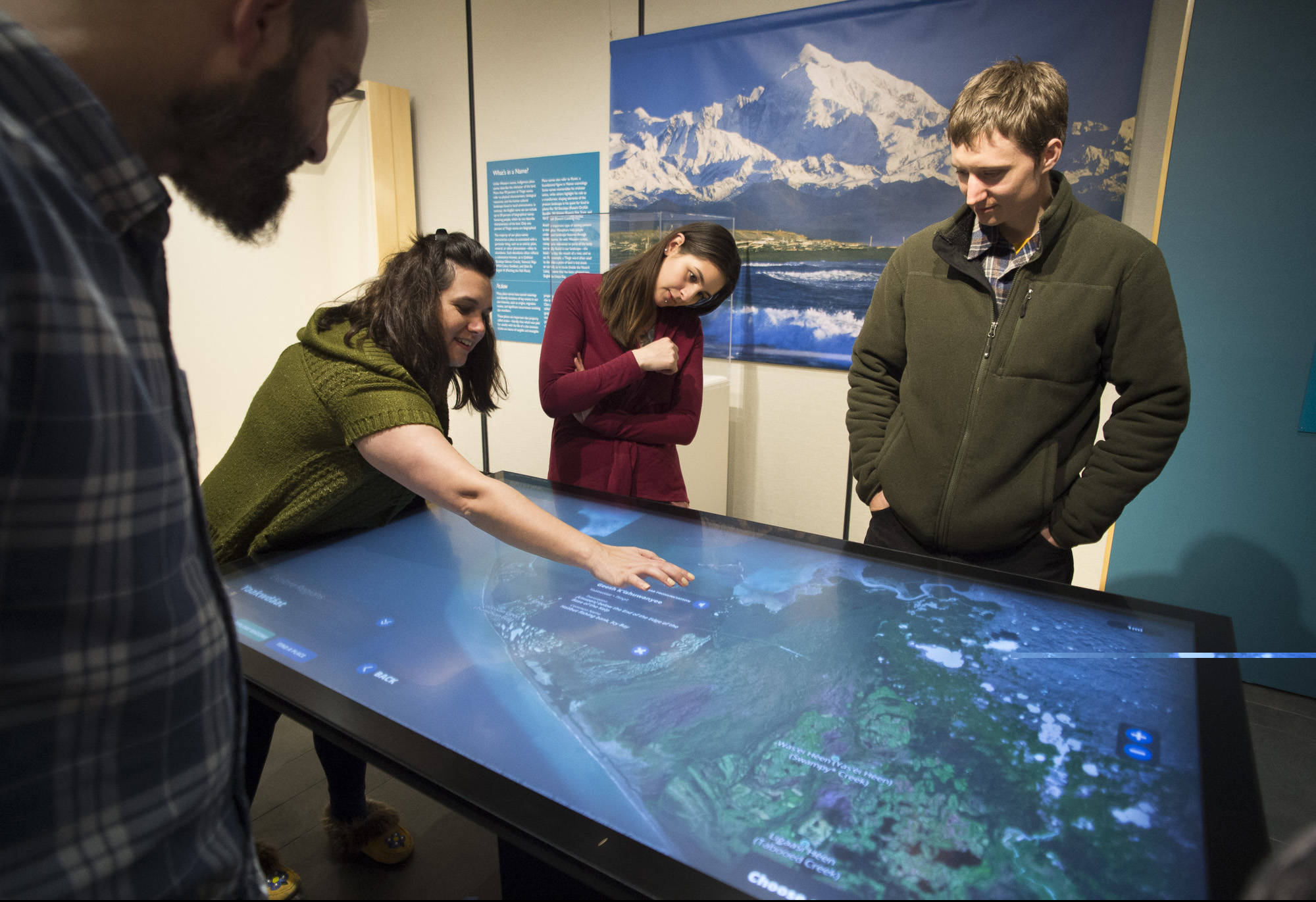 Sealaska Heritage Institute employees Mason Auger, left, Bobbie Meszaros, Jill Meserve and Will Geiger, right, explore a new interactive exhibit, “Our Grandparents’ Names on the Land,” in the Nathan Jackson Gallery in SHI’s Walter Soboleff Building on Thursday, April 26, 2018. The exhibit explores ancient place names and the innovative inventions that were used to catch halibut and salmon. The community is welcome to explore it free of charge on First Friday. (Michael Penn | Juneau Empire)