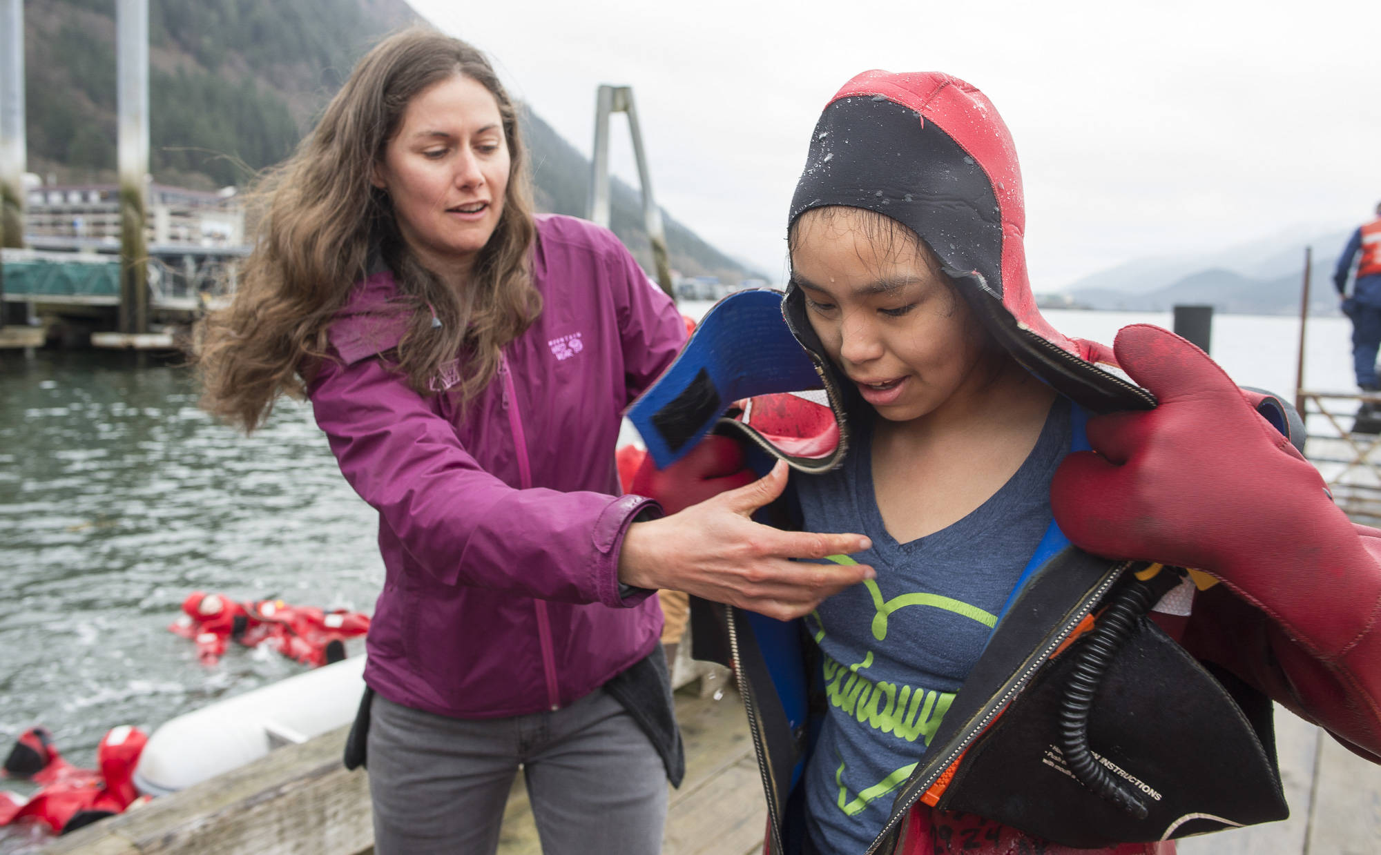 Dzantik’i Heeni Middle School sixth-grade receives help getting out of a wet survival suit by teacher Cheyenne Cuellar during a class from the Alaska Marine Safety Education Association at the U.S. Coast Guard’s Station Juneau dock on Monday, April 30, 2018. (Michael Penn | Juneau Empire)