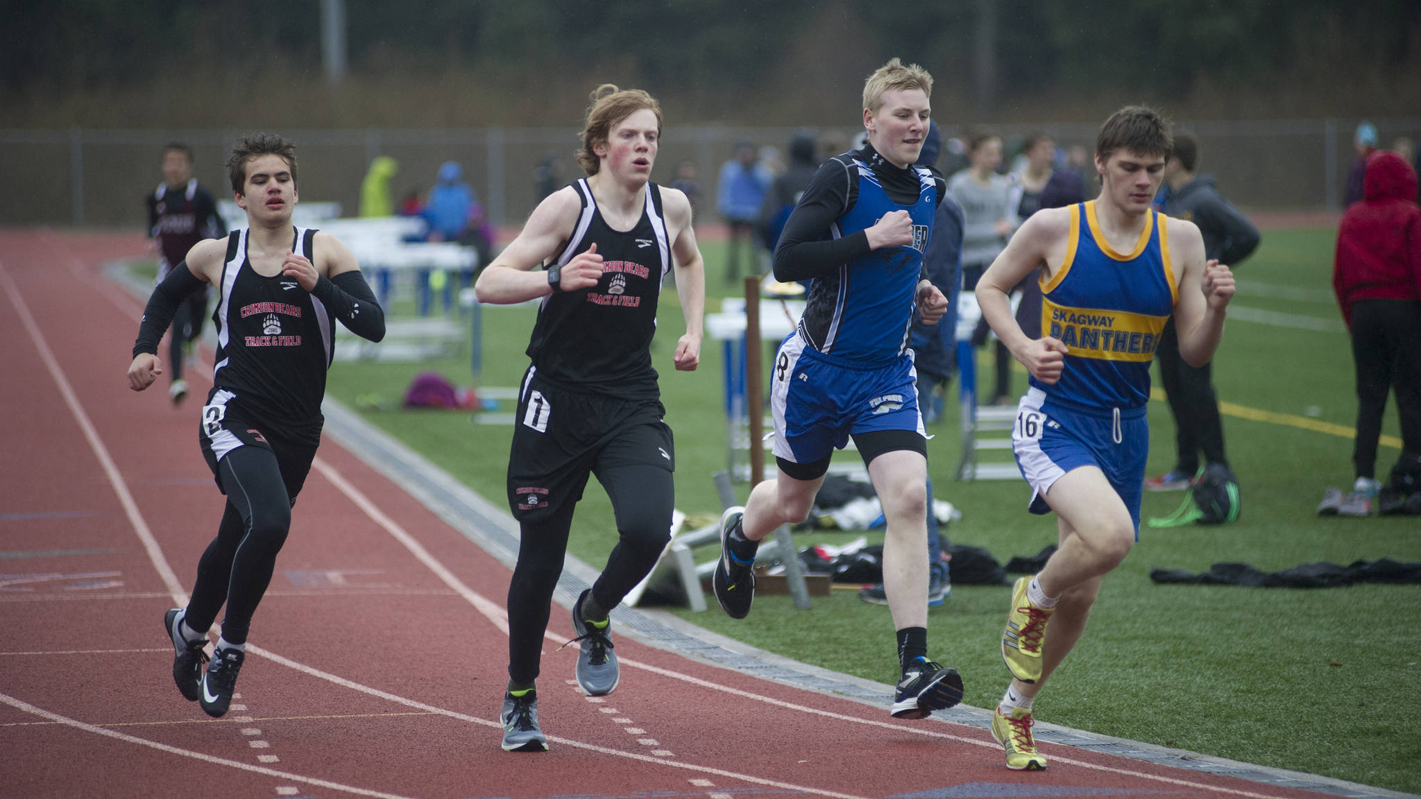Juneau-Douglas’ Ethan Sellers, far right, Owen Squires and Thunder Mountain’s Sam Dobson round the second lap of the 800-meter preliminary race on Friday at the Capital Invitational track and field meet hosted by TMHS and JDHS. (Richard McGrail | Juneau Empire)