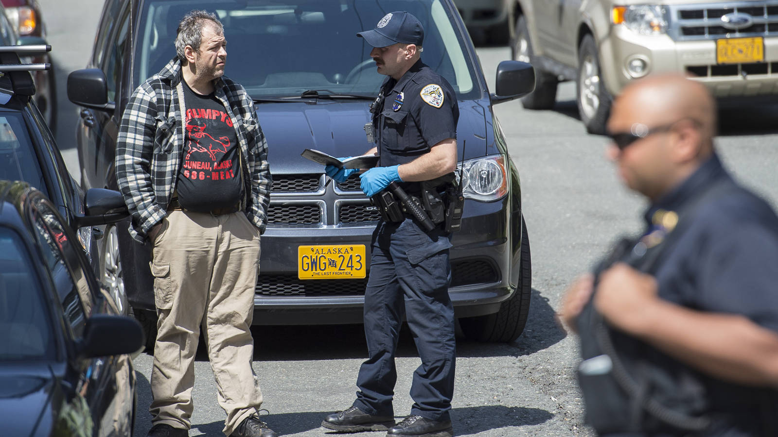 Juneau Police Department officers hold and question James Barrett and at least 10 other people during a raid at his house on 4th and Harris Streets on Wednesday, May 16, 2018. (Michael Penn | Juneau Empire)