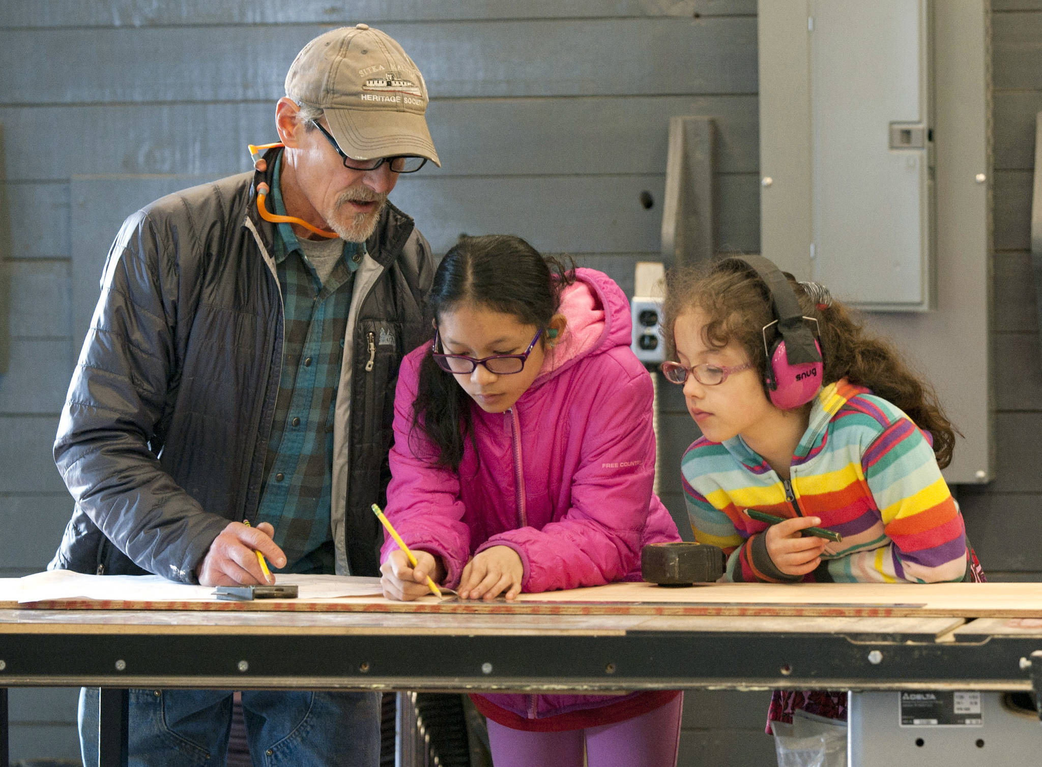 In this April 29, 2018 photo, Shipwright Joe D’Arenzio, left, shows Sitka 4-H students how to loft atterns to build skiffs at the Sitka Maritime Heritage Society’s WWII-era boathouse in Sitka, Alaska. The budding boatwrights are participating in a 4-H program to build two rowing and sailing dories in weekly Sunday afternoon installments and under the supervision of local boatwrights. James Poulson | Associated Press