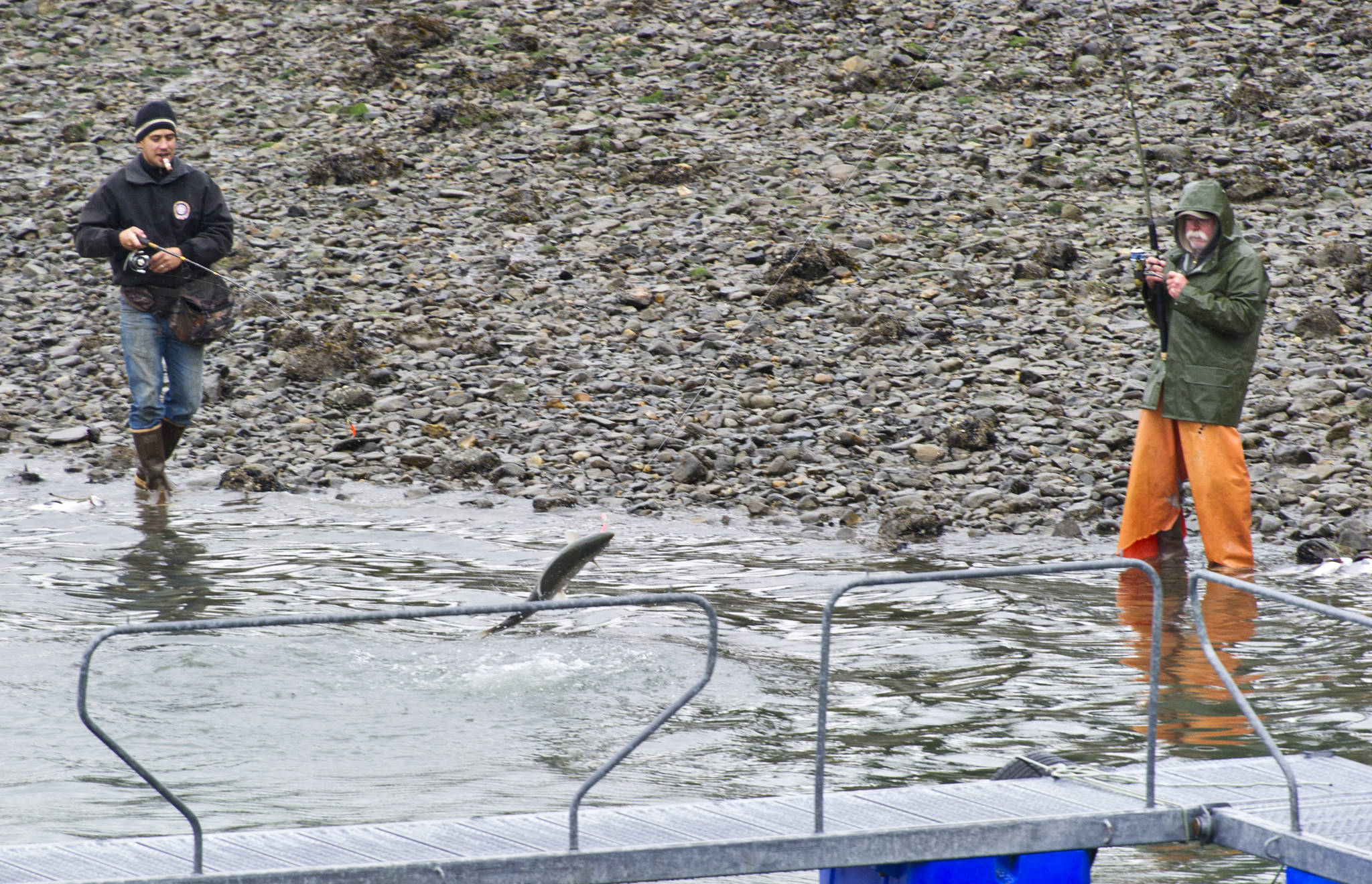 In this September 2015 photo, Greg Gallant, right, fights a silver salmon as Ishiah Campos fishes nearby at the DIPAC Macaulay Salmon Hatchery. (Michael Penn | Juneau Empire File)