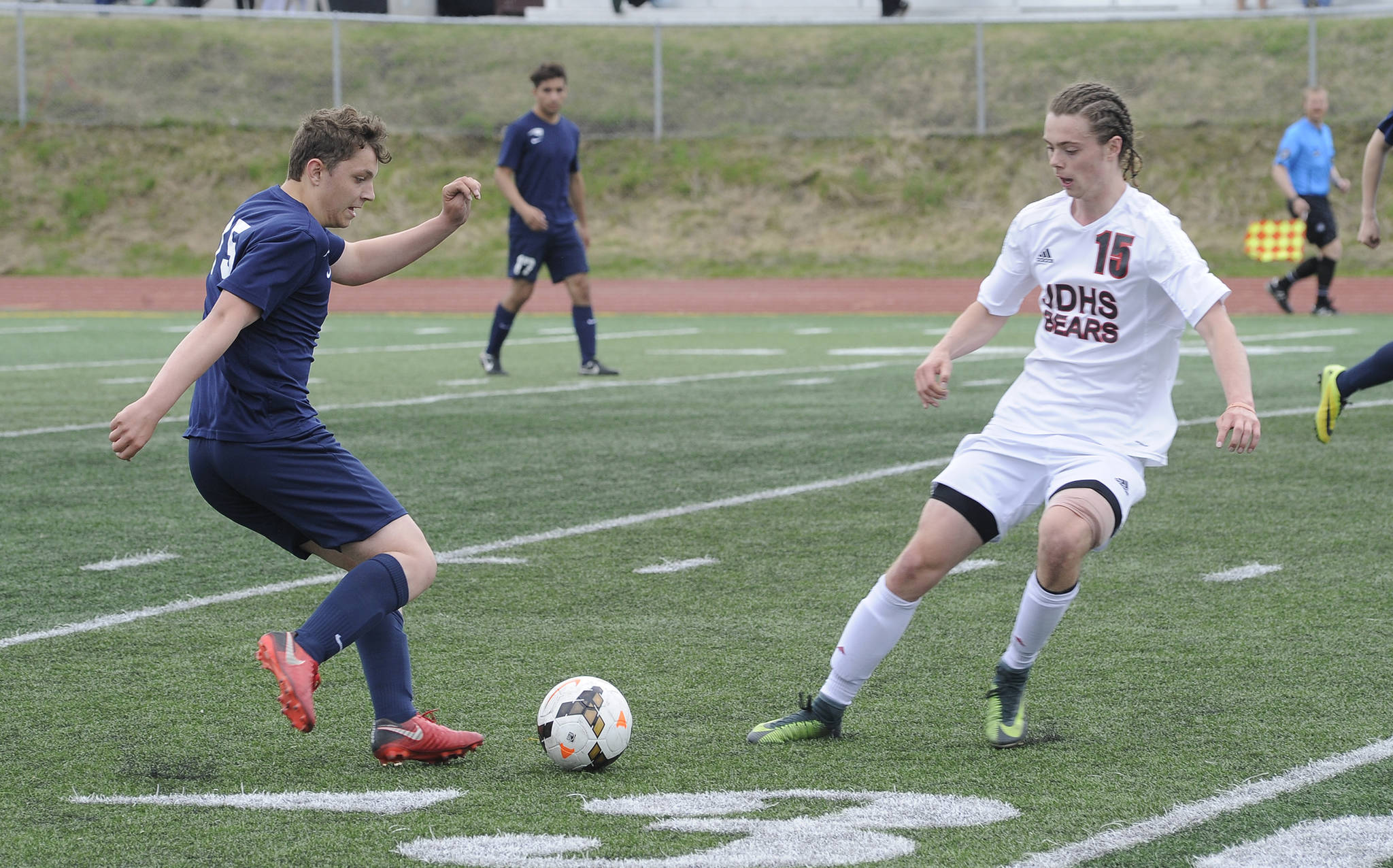 Juneau-Douglas High School senior Brysen Mitchell pressures North Pole’s Justin Howard in the ASAA Division II boys soccer state championships, Friday, May 25, 2018. (Nolin Ainsworth | Juneau Empire)