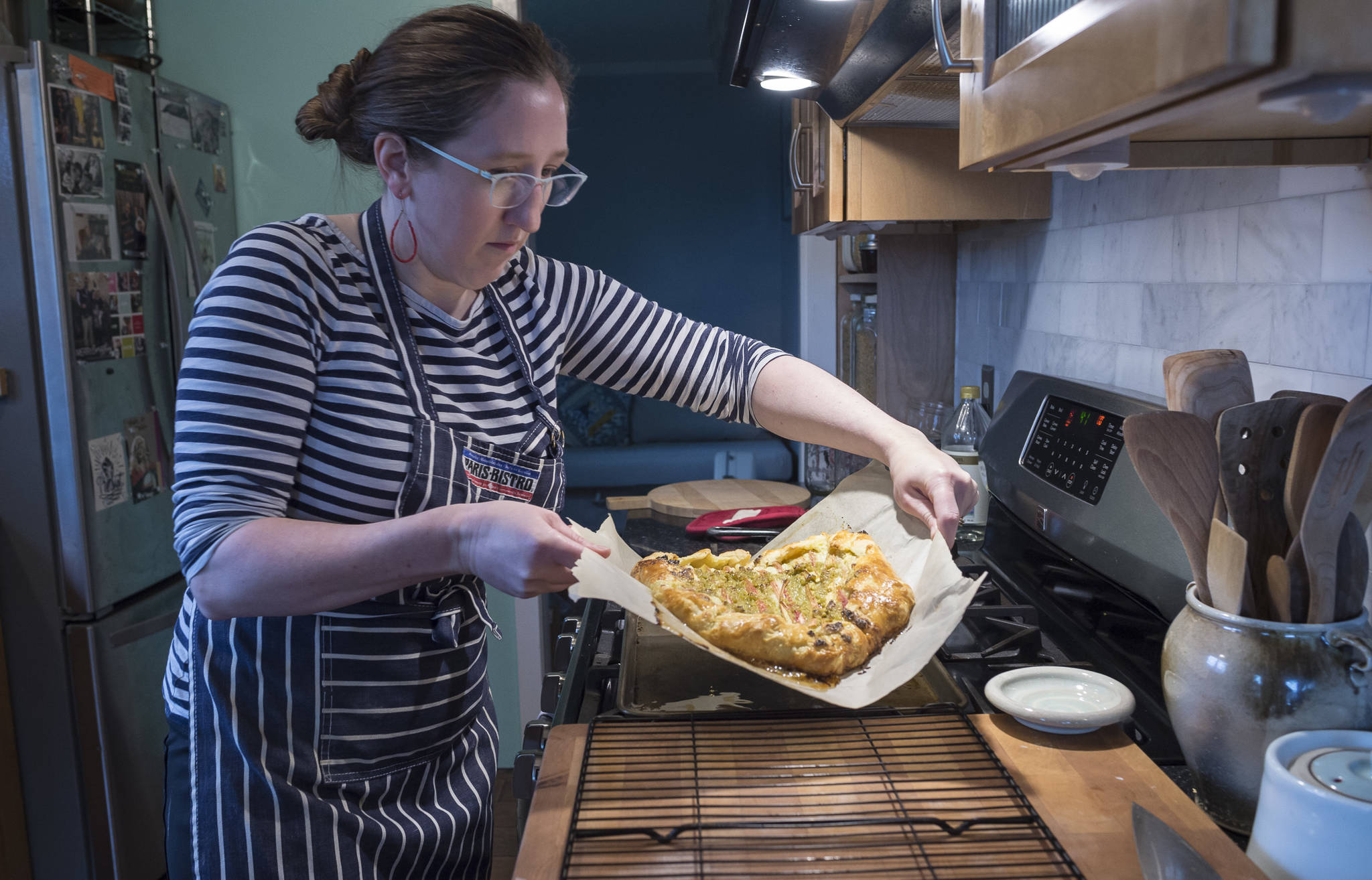 Erin Anais Heist, author of a new cooking column called “Eating Wild” for the Juneau Empire, transfers her galette made with with rhubarb, spruce tip and ricotta cheese to a cooling rack in her home kitchen on Monday, May 21, 2018. (Michael Penn | Juneau Empire)