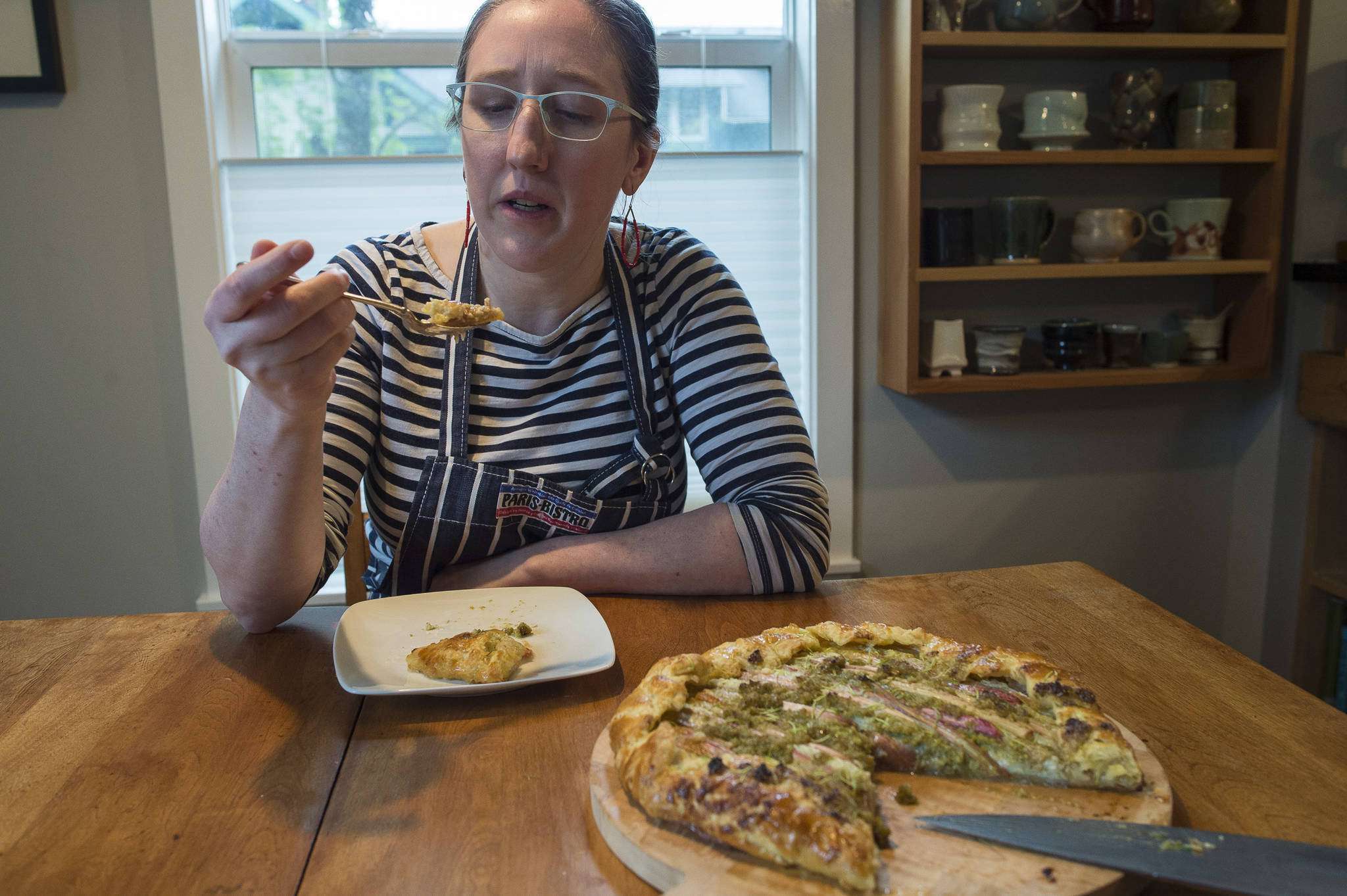 Erin Anais Heist, author of a new cooking column called “Eating Wild” for the Juneau Empire, studies the flavors in her galette made with with rhubarb, spruce tip and ricotta cheese in her home kitchen on Monday, May 21, 2018. (Michael Penn | Juneau Empire)