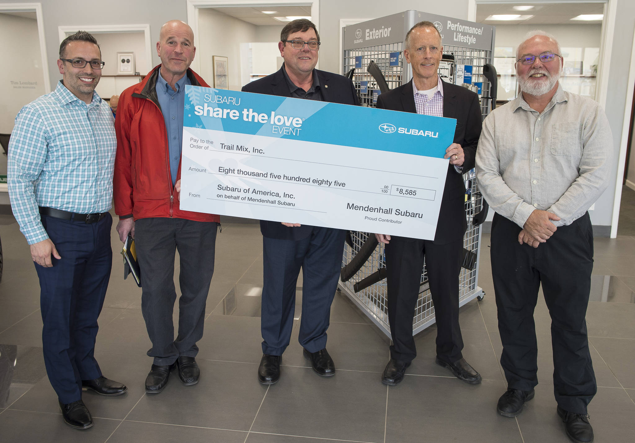 Phil Saraceno, left, of Subaru of America, Co-owners Mark Troupin, and Steve Allwine, of Mendenhall Auto, present as check to Doug Scudder, president of the Board of Directors for Trail Mix Inc., second from right, and Ron Bressette, vice president of Trail Mix, right, at Mendenhall Auto on Tuesday, May 29, 2018. The donation is part of Subaru’s Share the Love promotion. (Michael Penn | Juneau Empire)