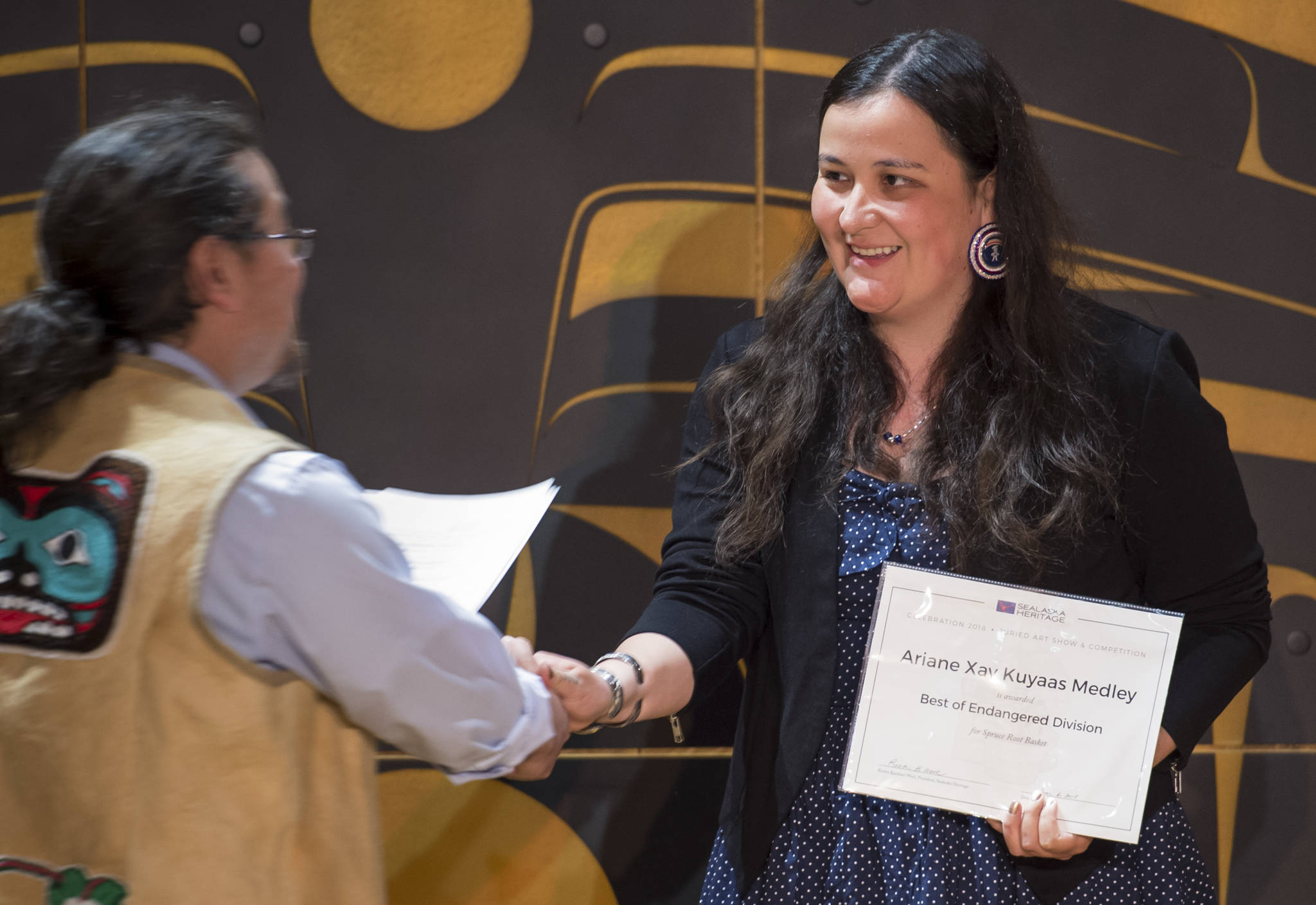 Ariane Xay Kuyaas Medley is presented her Best of Endangered Division award from Joe Nelson at Sealaska Heritage Institute’s Juried Art Competition award ceremony at the Walter Soboleff Center on Wednesday, June 6, 2018. Medley went on to win the Best of Show. (Michael Penn | Juneau Empire)