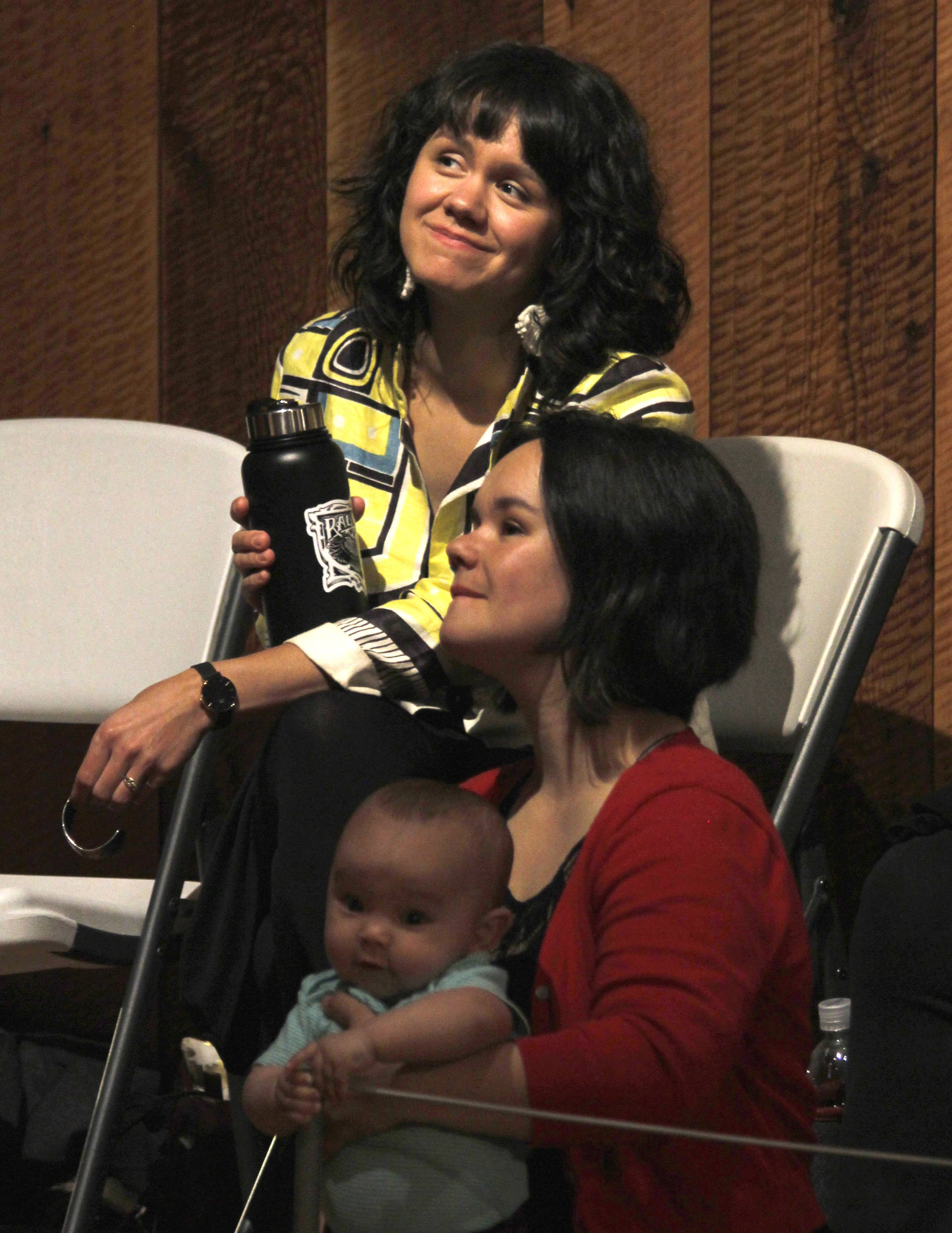 Sisters Ursala Hudson (top) and Lily Hope watch part of a presentation they led entitled “Listening to our Teachers: Bringing History to the Present in Chilkat and Ravenstail Weaving” inside the Walter Soboleff Building’s clan house on Wednesday, June 6, 2018. Hope holds her 8-month-old daughter Anastasia. (Alex McCarthy | Juneau Empire)