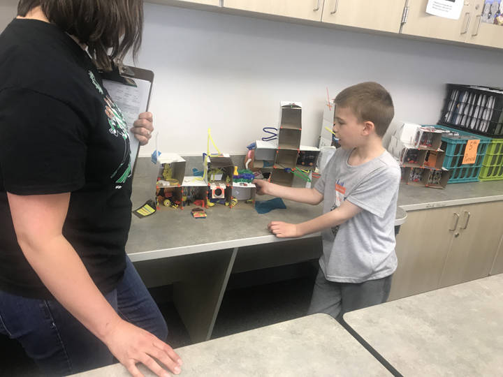 Brennan Fisher, a third-grader at Auke Bay Elementary School, describes the mansion he built during Camp Invention this past week at Thunder Mountain High School. (Gregory Philson | Juneau Empire)