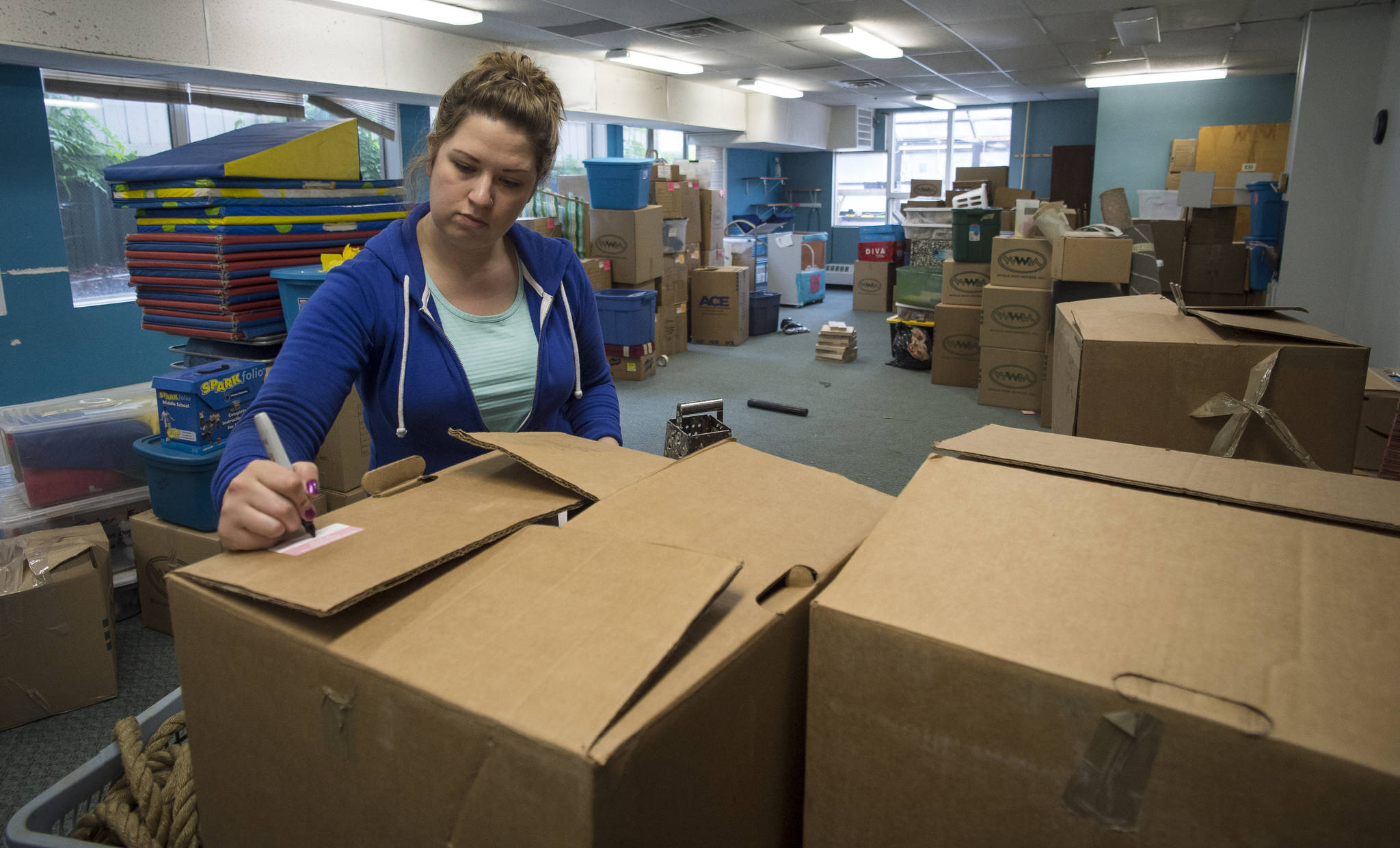 Teacher Lindsay Hulbert labels boxes on Monday, June 11, 2018, as the Juneau Community Charter School prepares to move out of the Arctic Corp building this summer. The school is moving into space at Juneau-Douglas High School. (Michael Penn | Juneau Empire)