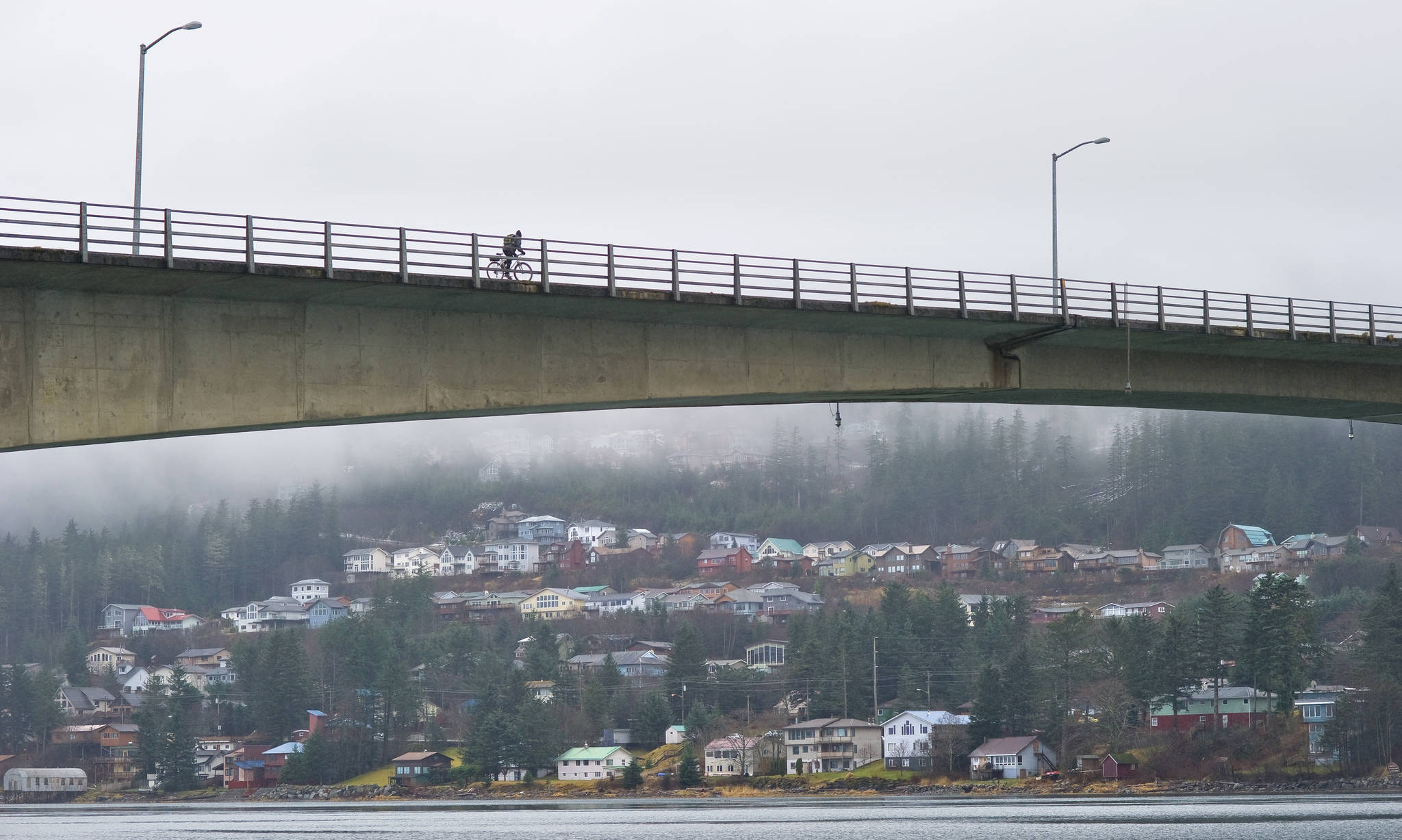 A bicyclist cross the Douglas Bridge in November 2012. The bridge is the only connection to Douglas Island from the mainland. (Michael Penn | Juneau Empire File)